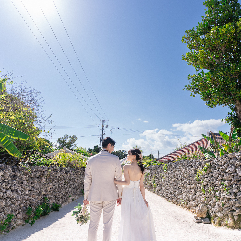 竹富島の集落で腕を組んで立つ新郎新婦の後ろ姿新郎新婦