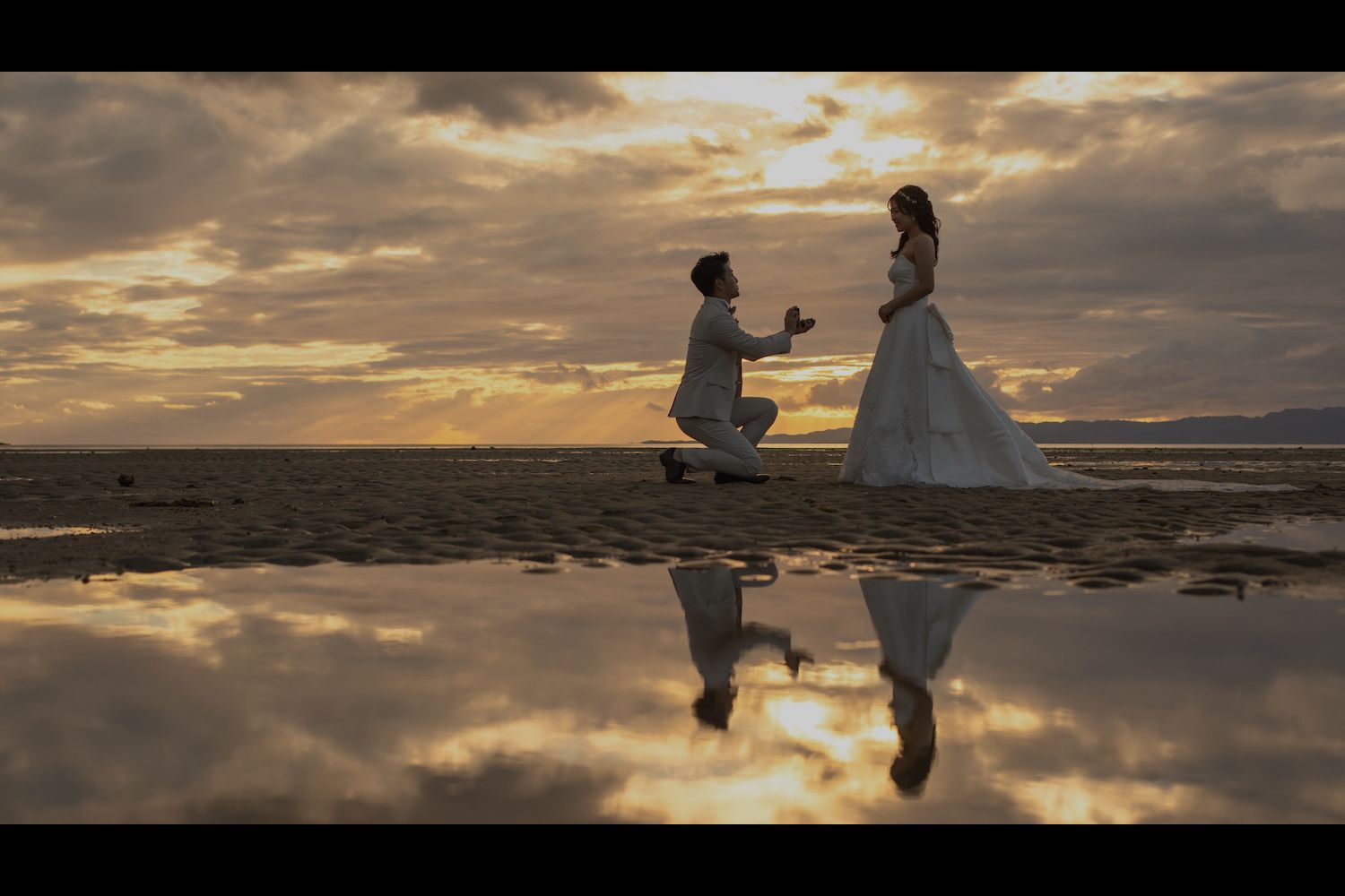 石垣島の海でサンセットを前に新婦へプロポーズをする新郎