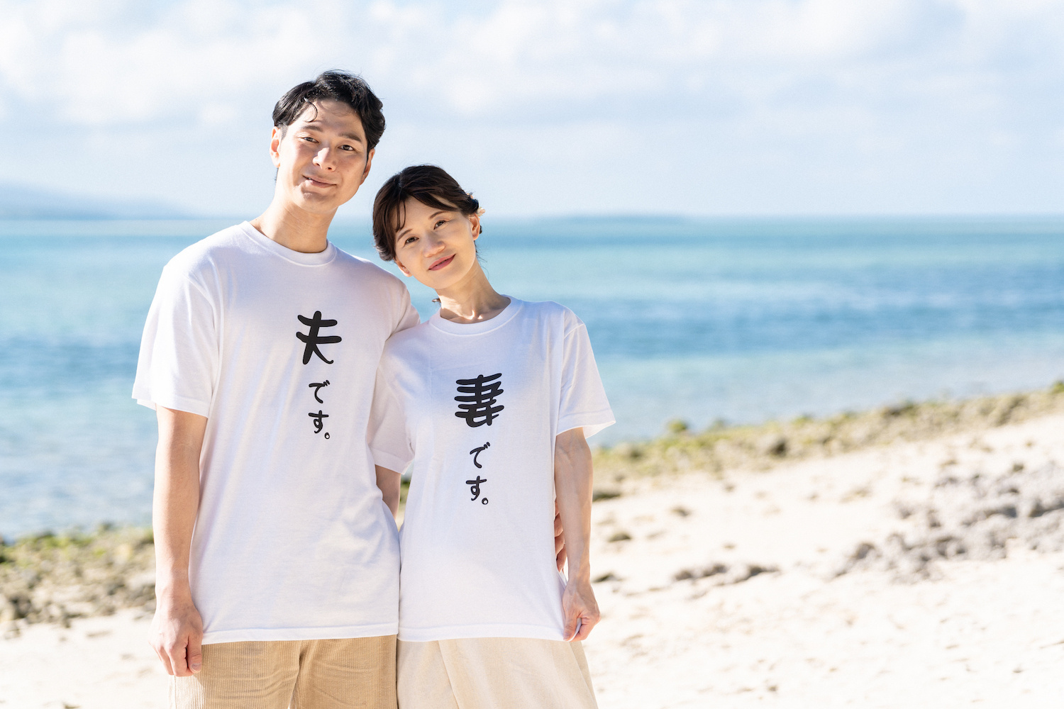 竹富島のカイジ浜でおそろいのTシャツで寄り添って立つ新郎新婦