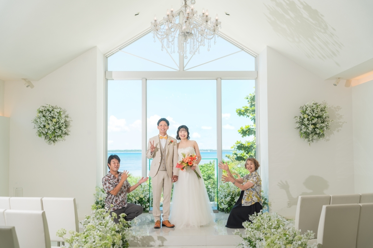 青空を背景にブーケを掲げている新婦