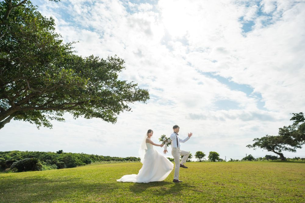 ビーチにある大きな木の下で抱き合う新郎新婦