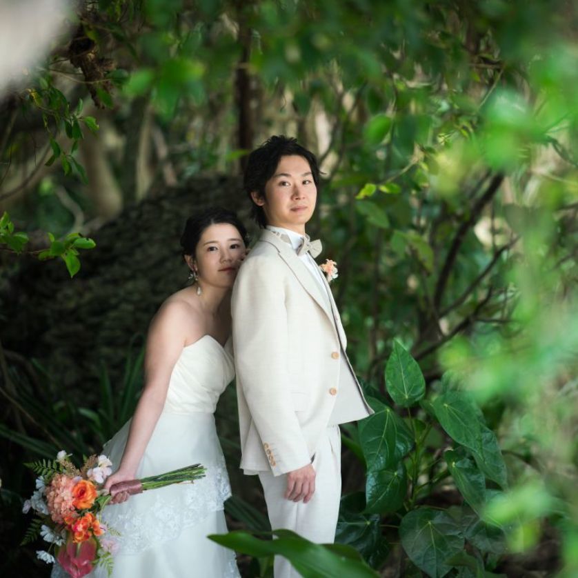 家族に囲まれてビーチセレモニーを行う新郎新婦