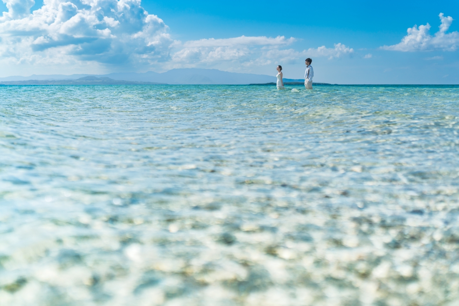 遠浅の海に立つ新郎新婦