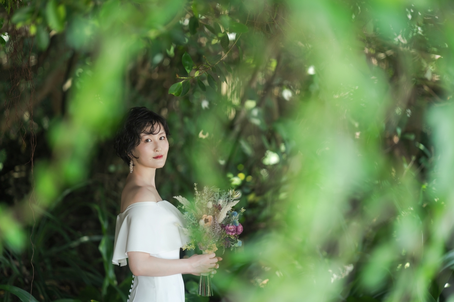 緑に囲まれて立つ新婦