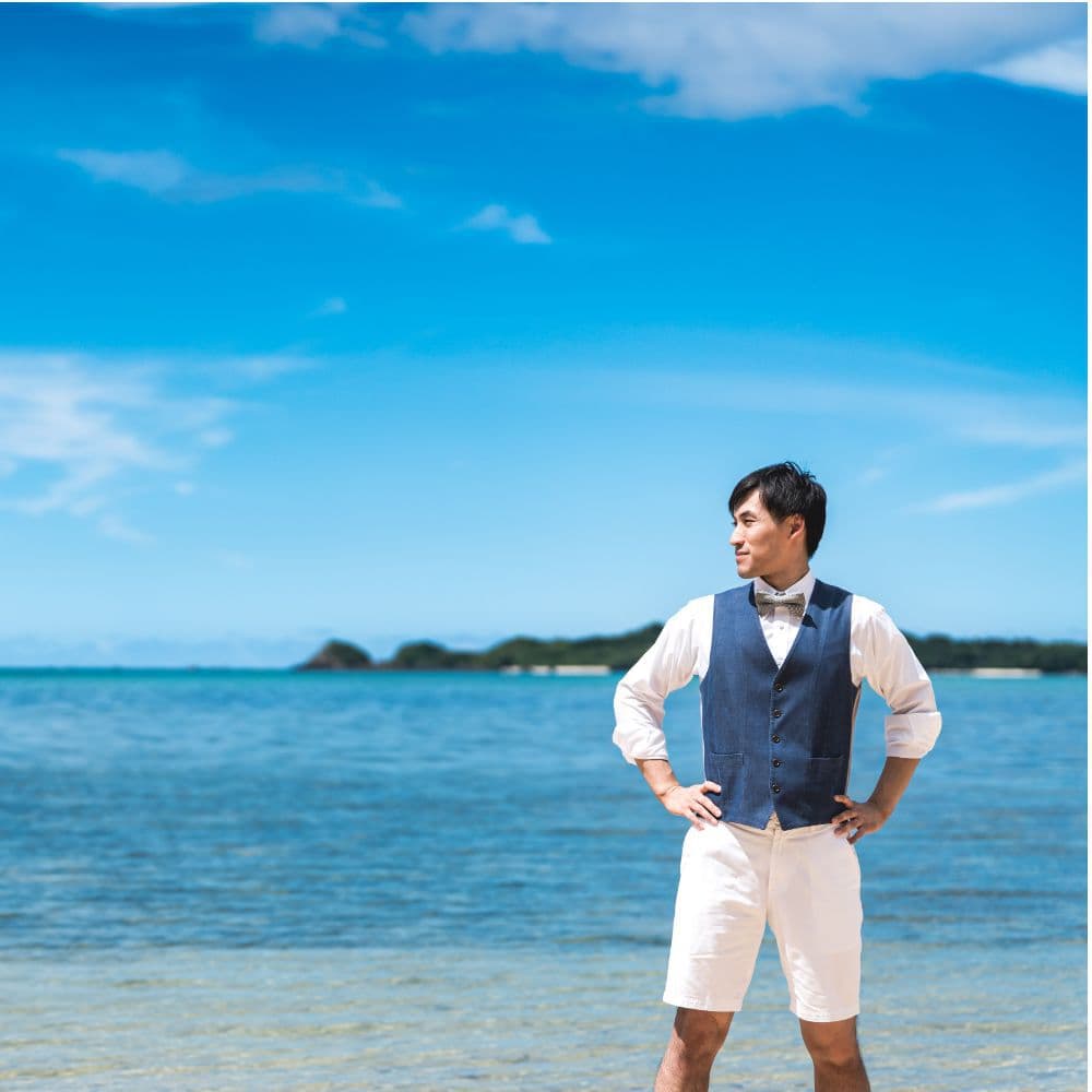 海を背景に遠くを見て佇む新郎