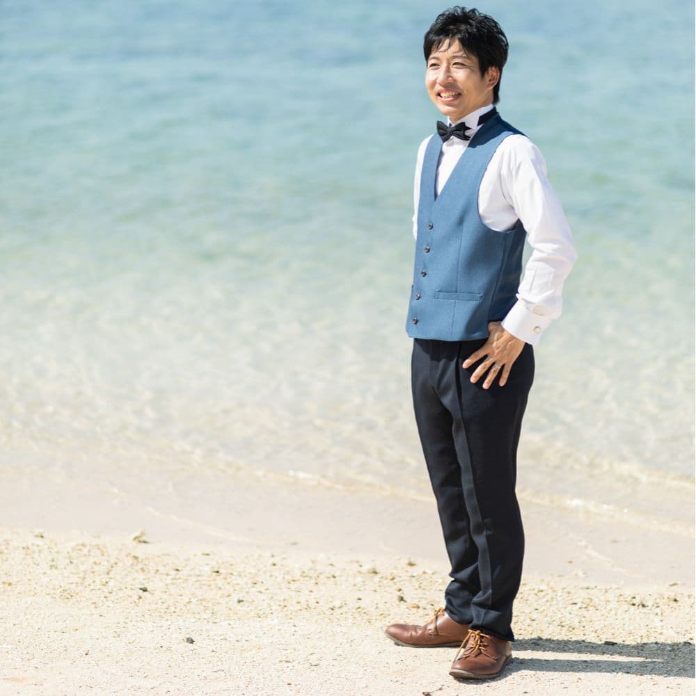海を背景に立つ新郎