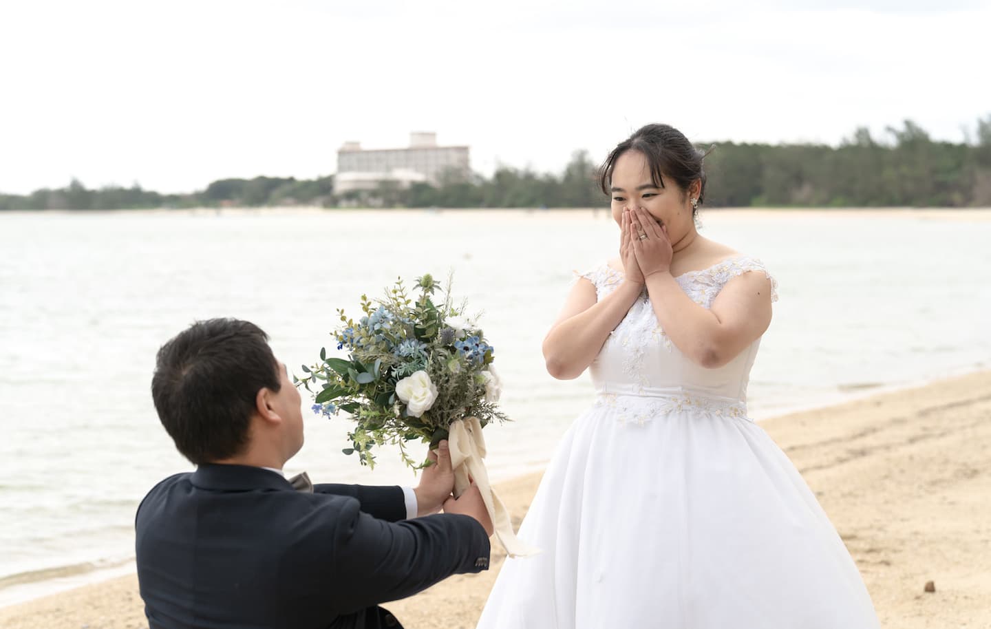底地ビーチで海を背景に新婦へブーケを渡す新郎