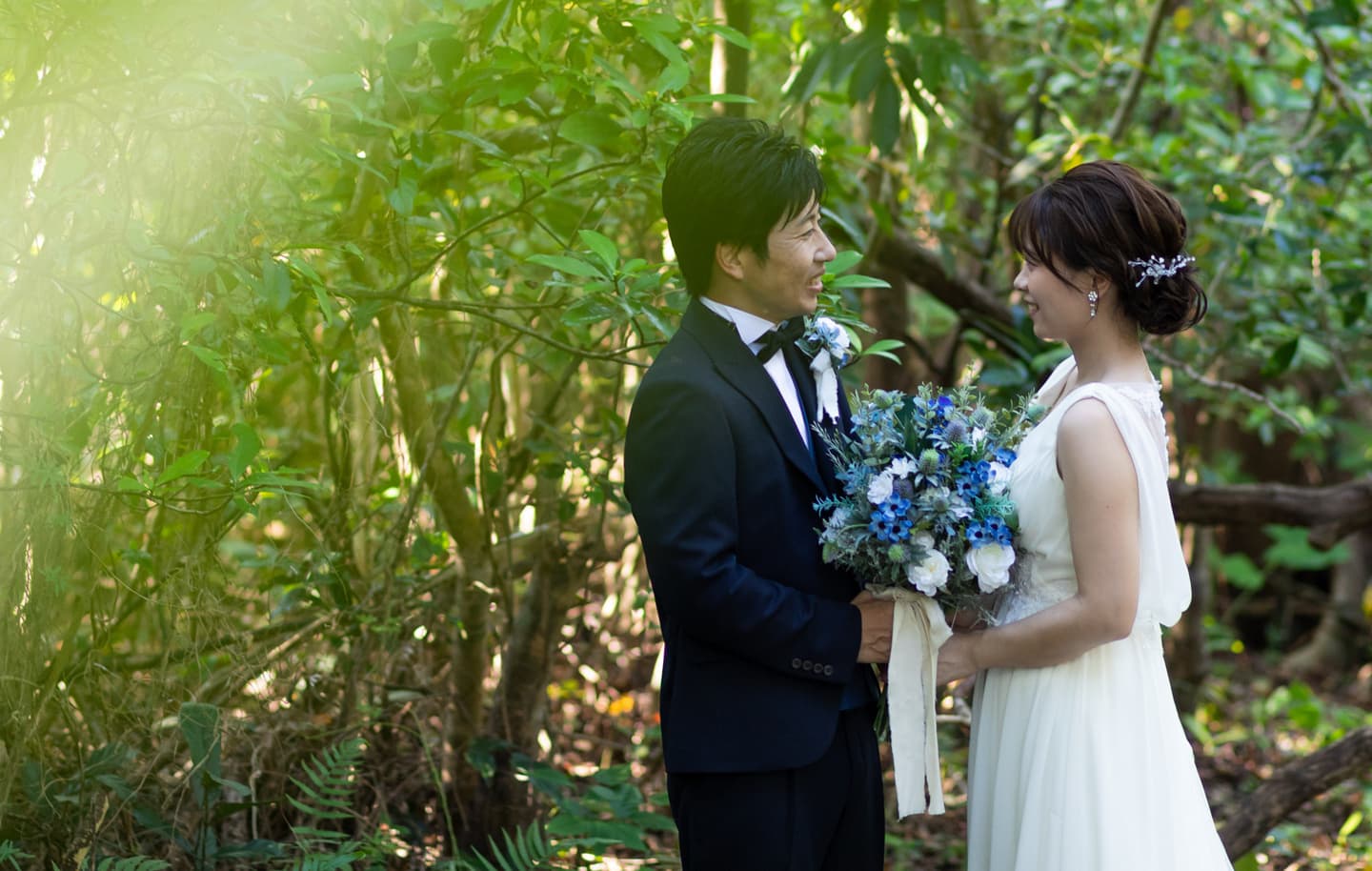 グリーンに囲まれて見つめ合う新郎新婦