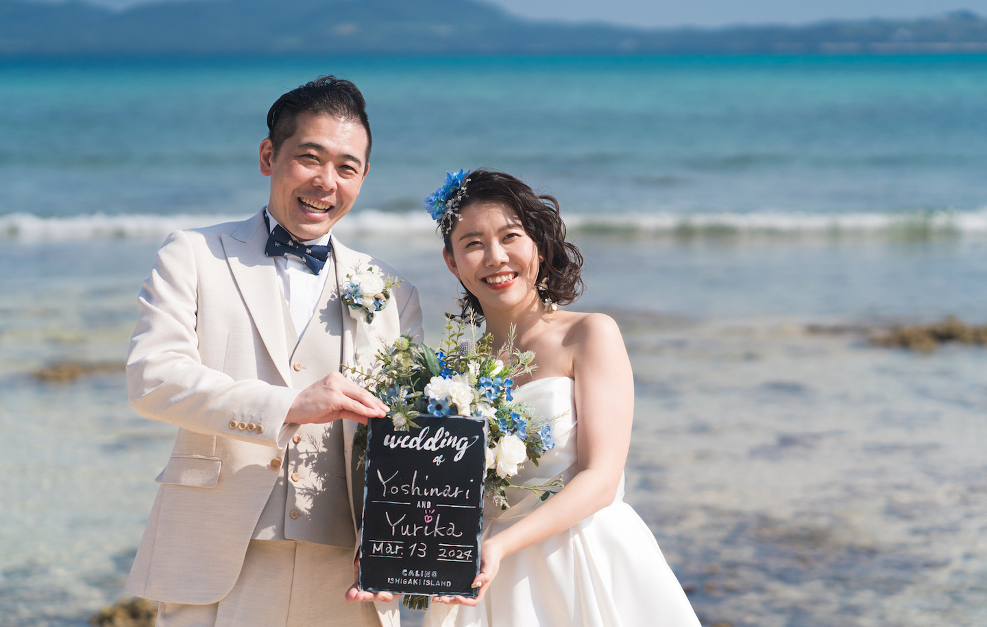 夕焼けに染まる空を背景に新婦へブーケを渡す新郎
