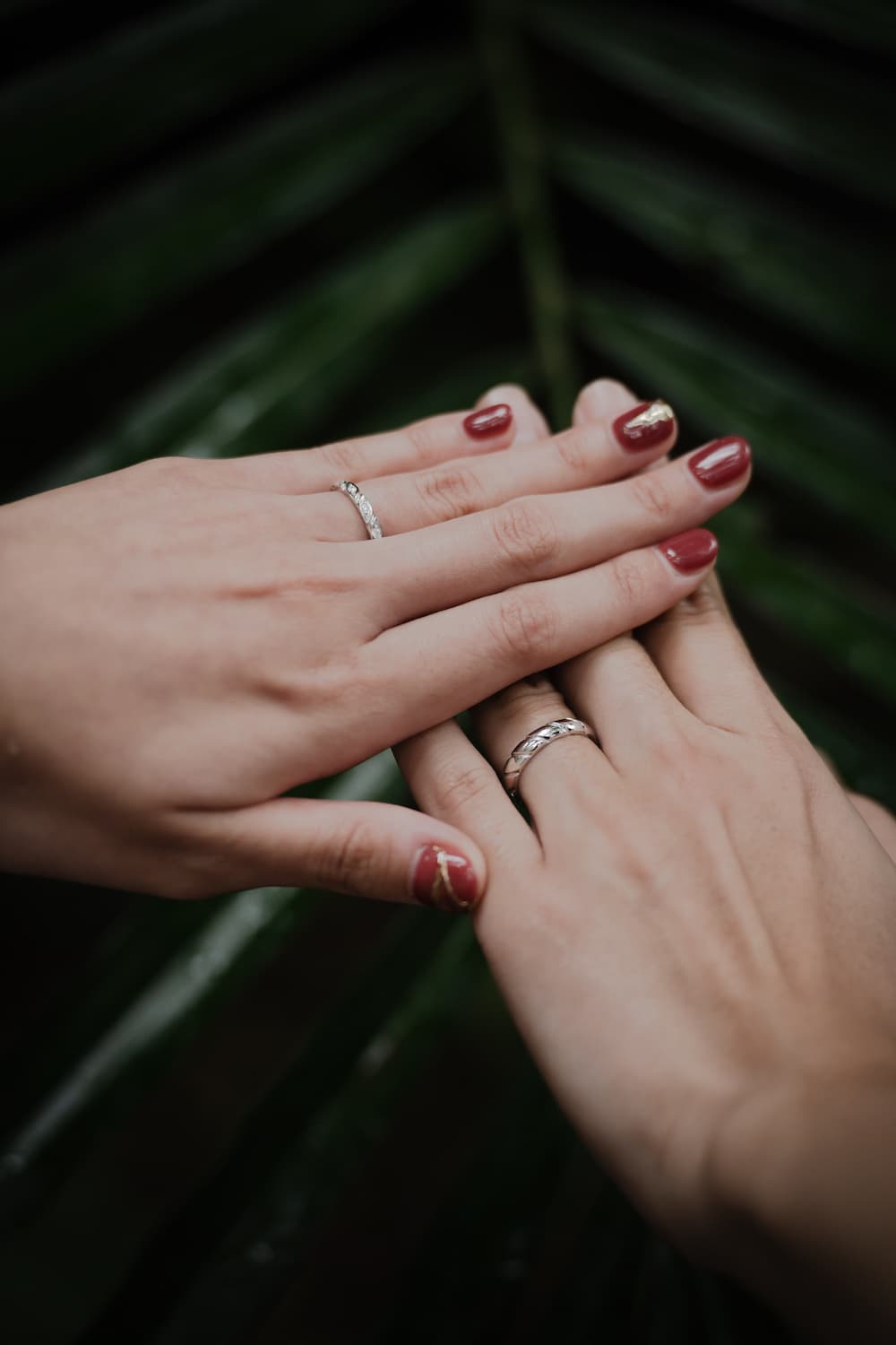 指輪をはめた手を重ねる新郎新婦の手元