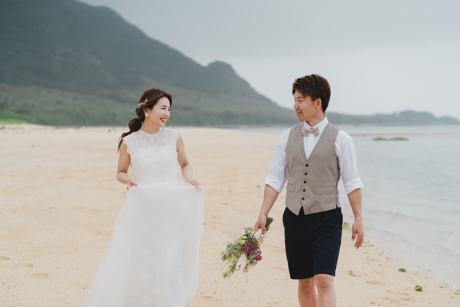 浜辺を話しながら歩く新郎新婦