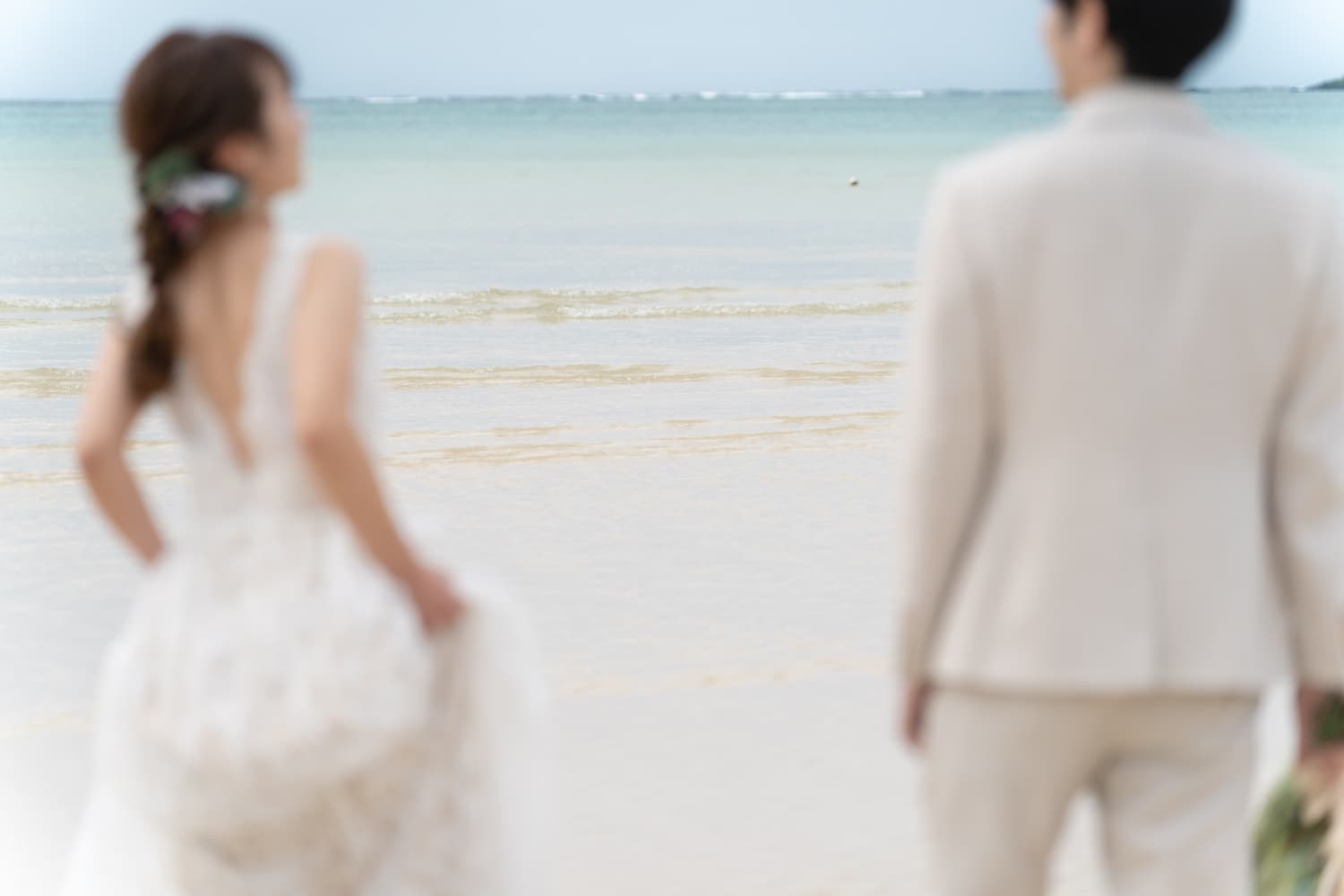 海を眺める新郎新婦の後ろ姿