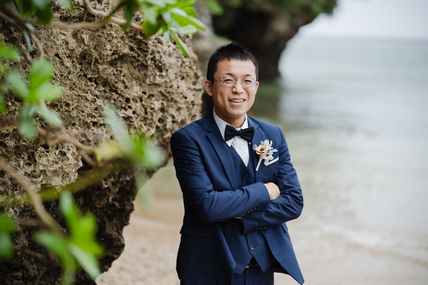 石垣島のビーチで岩場に寄りかかる新郎