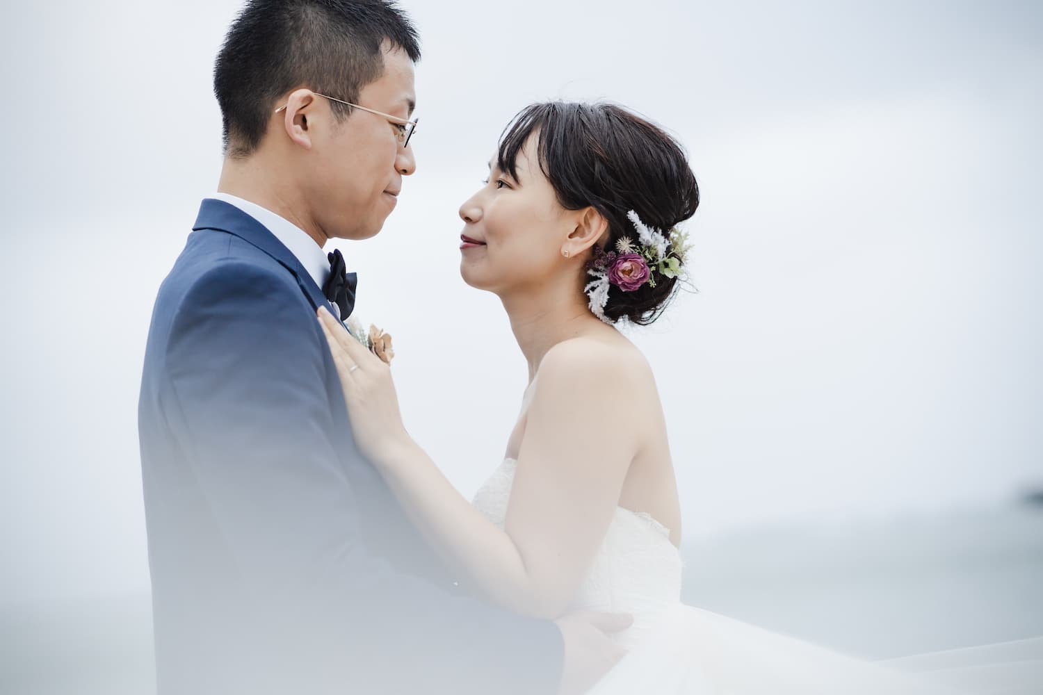 石垣島の海を背景に抱き合う新郎新婦