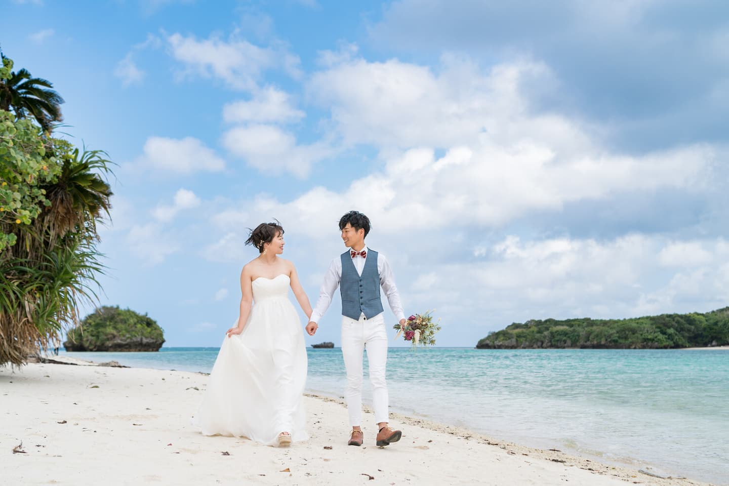 川平湾の浜辺を歩く新郎新婦
