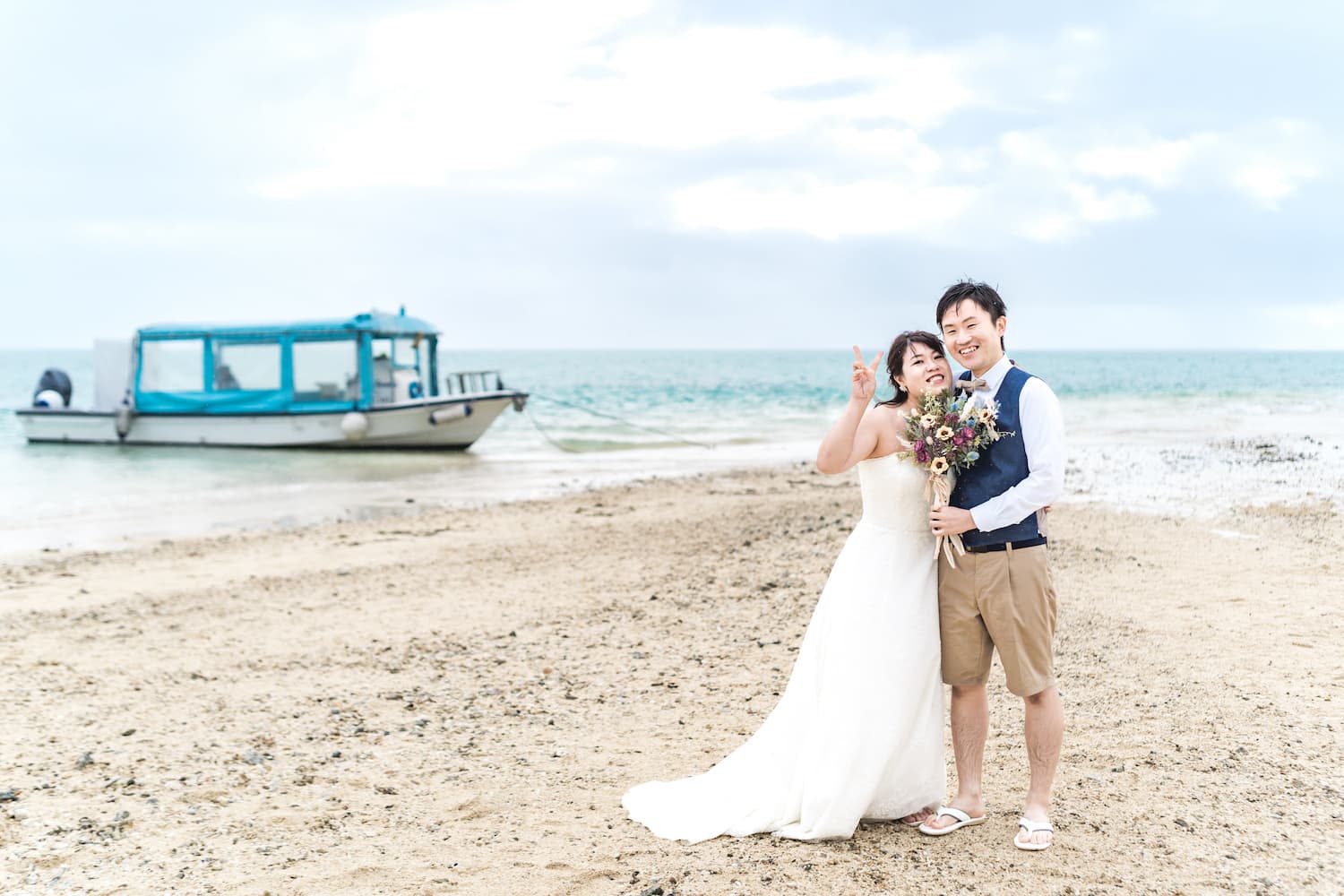 海を背景に立つ新郎新婦