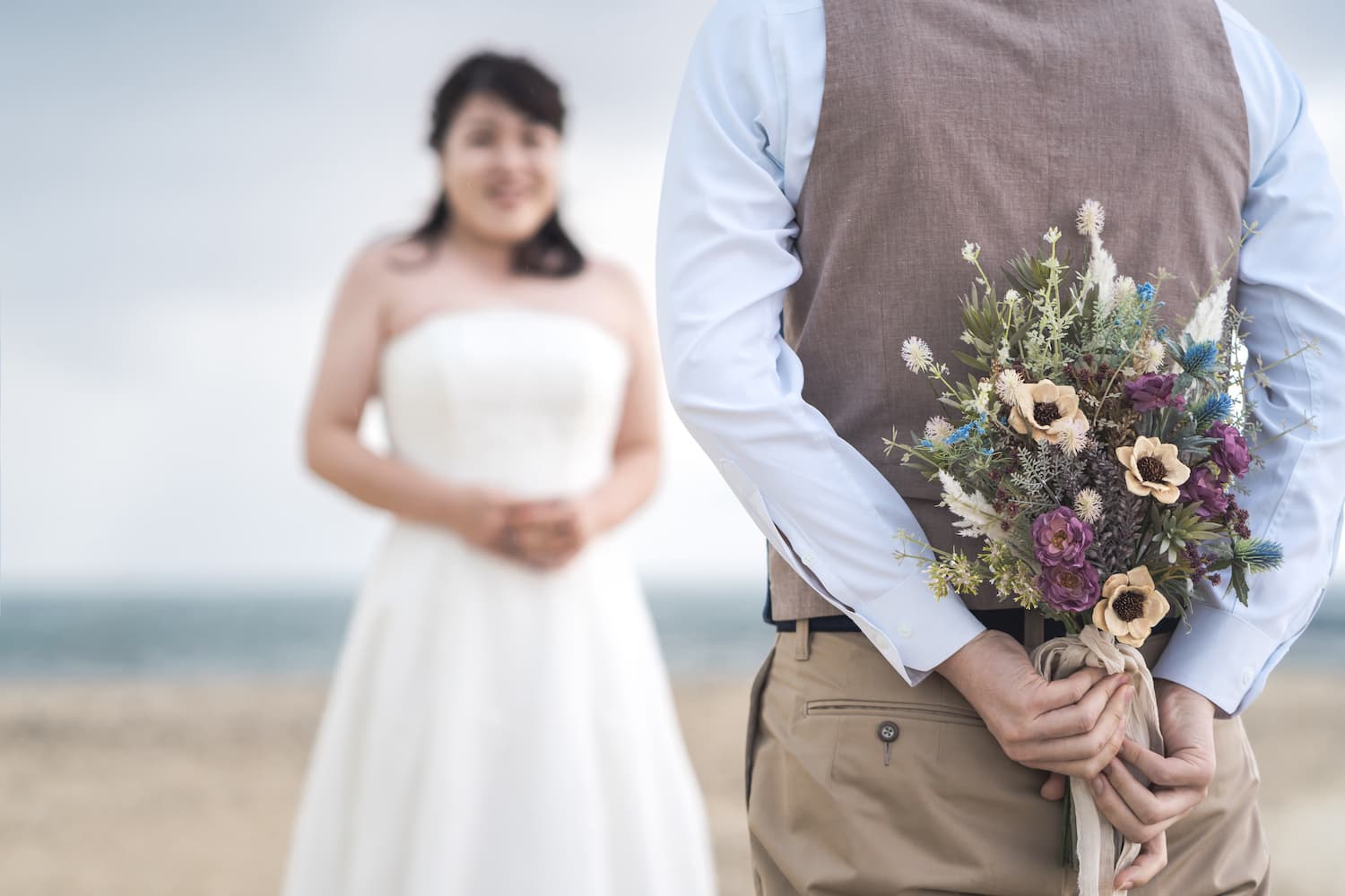 後ろでにブーケを持つ新郎と新婦
