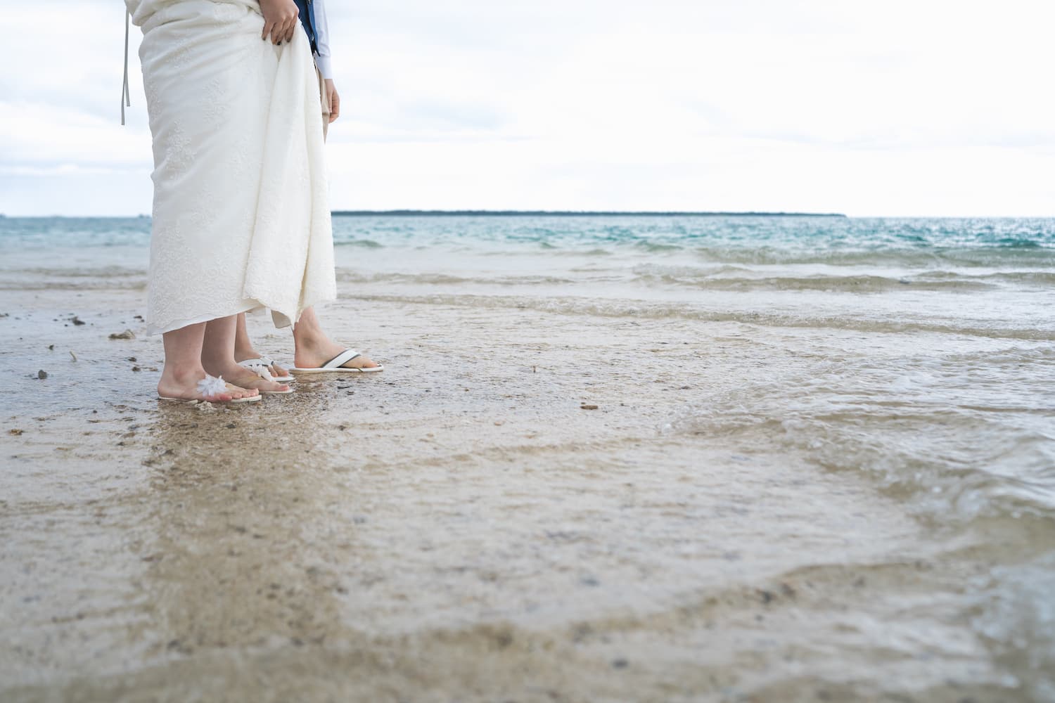 海に足を踏み入れる新郎新婦の足元