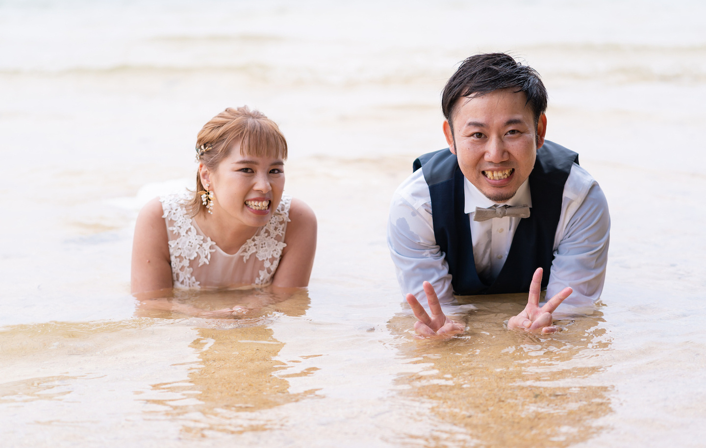 海に入って寝転がる新郎新婦