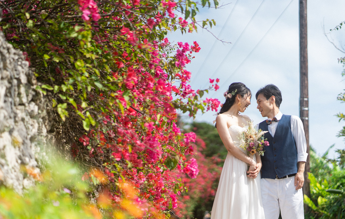 ビーチのセレモニー会場で新郎新婦と手を繋ぐ子供の後ろ姿