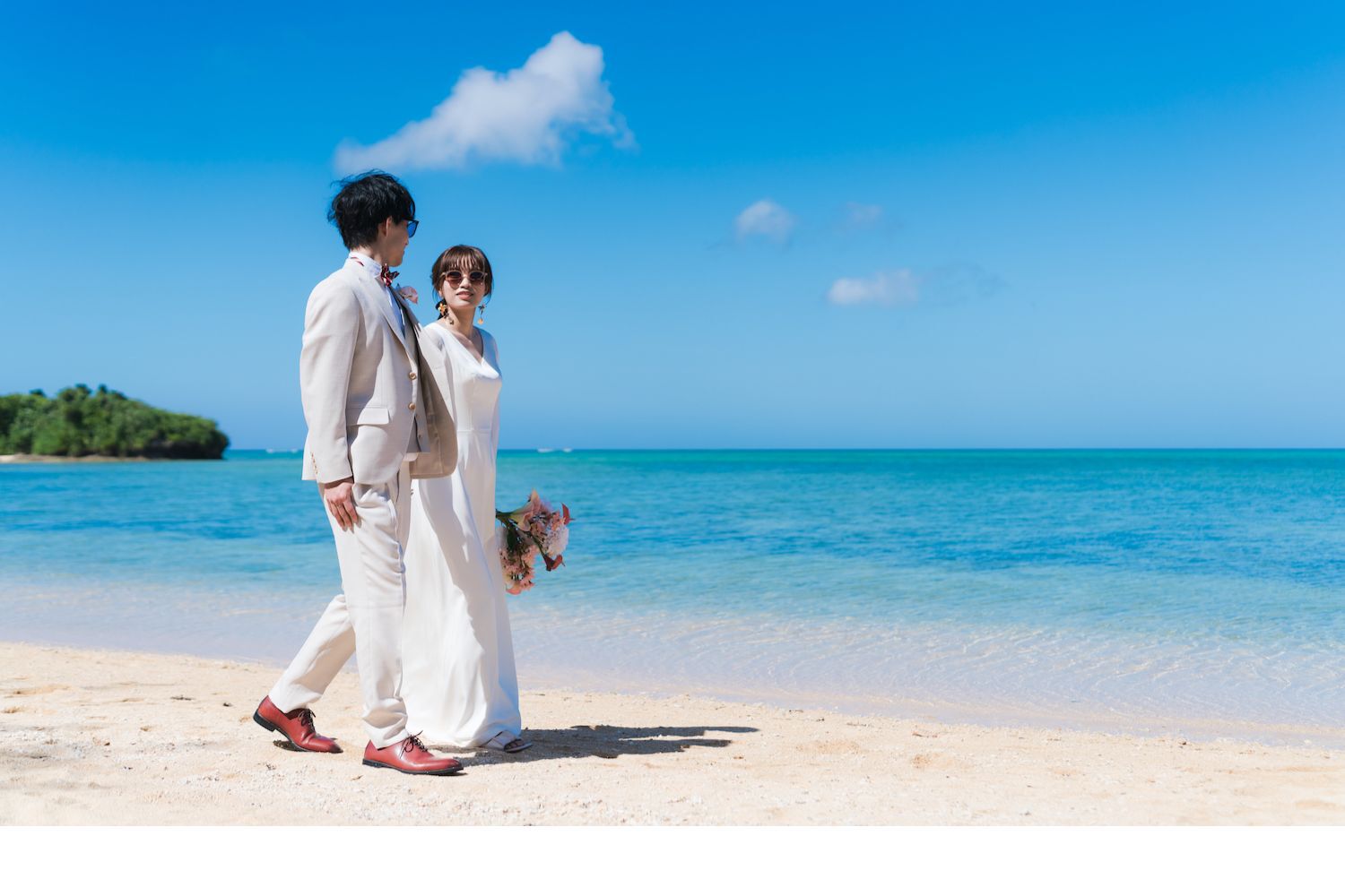 浜辺を歩く新郎新婦