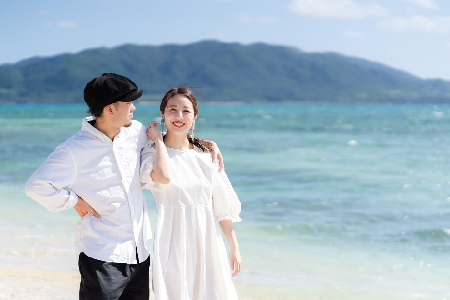 石垣島の海を背景に私服で肩を組む新郎新婦