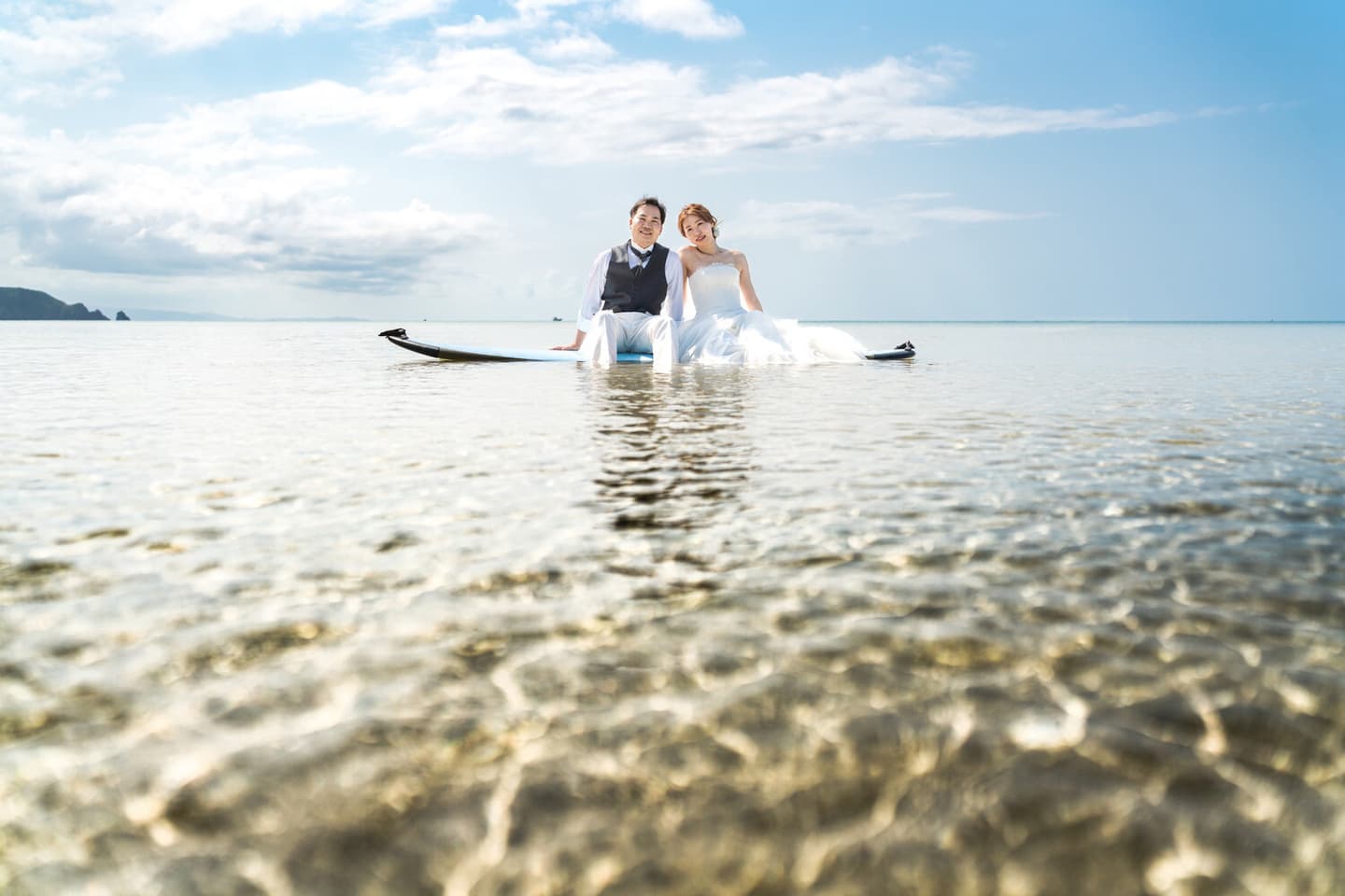 底地ビーチの海でSUPを楽しむ新郎新婦