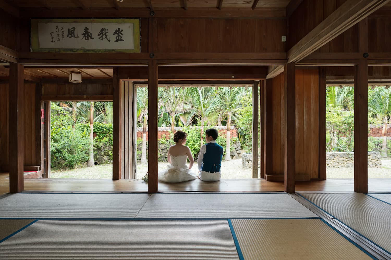 やいま村にある古民家の中で縁側に座る新郎新婦