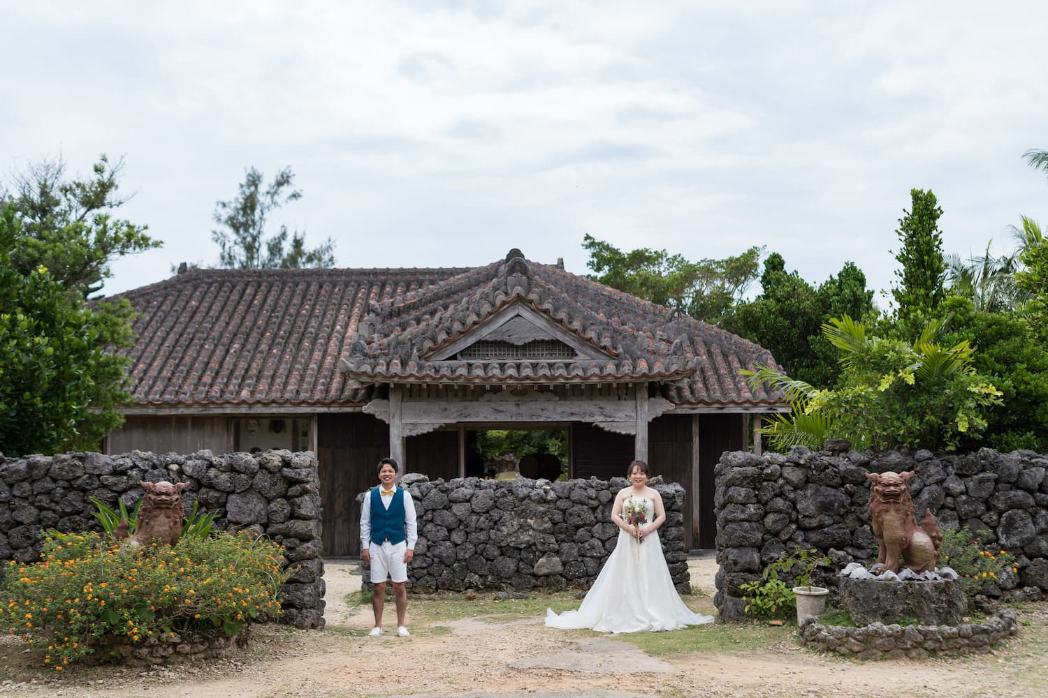 やいま村にある古民家の前に立つ新郎新婦
