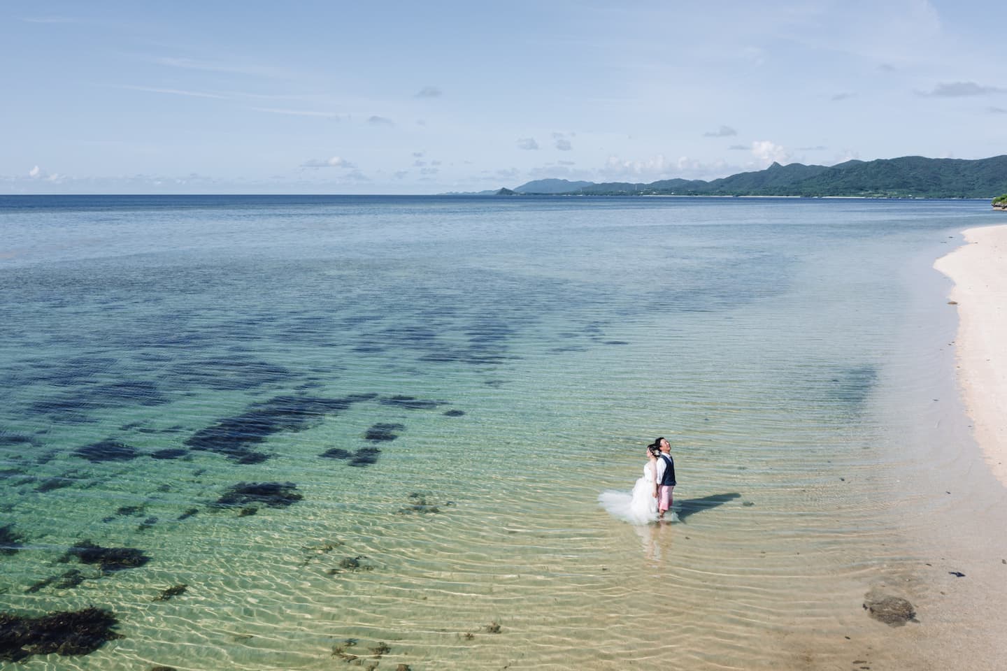 米原ビーチの海に入る新郎新婦のドローン写真