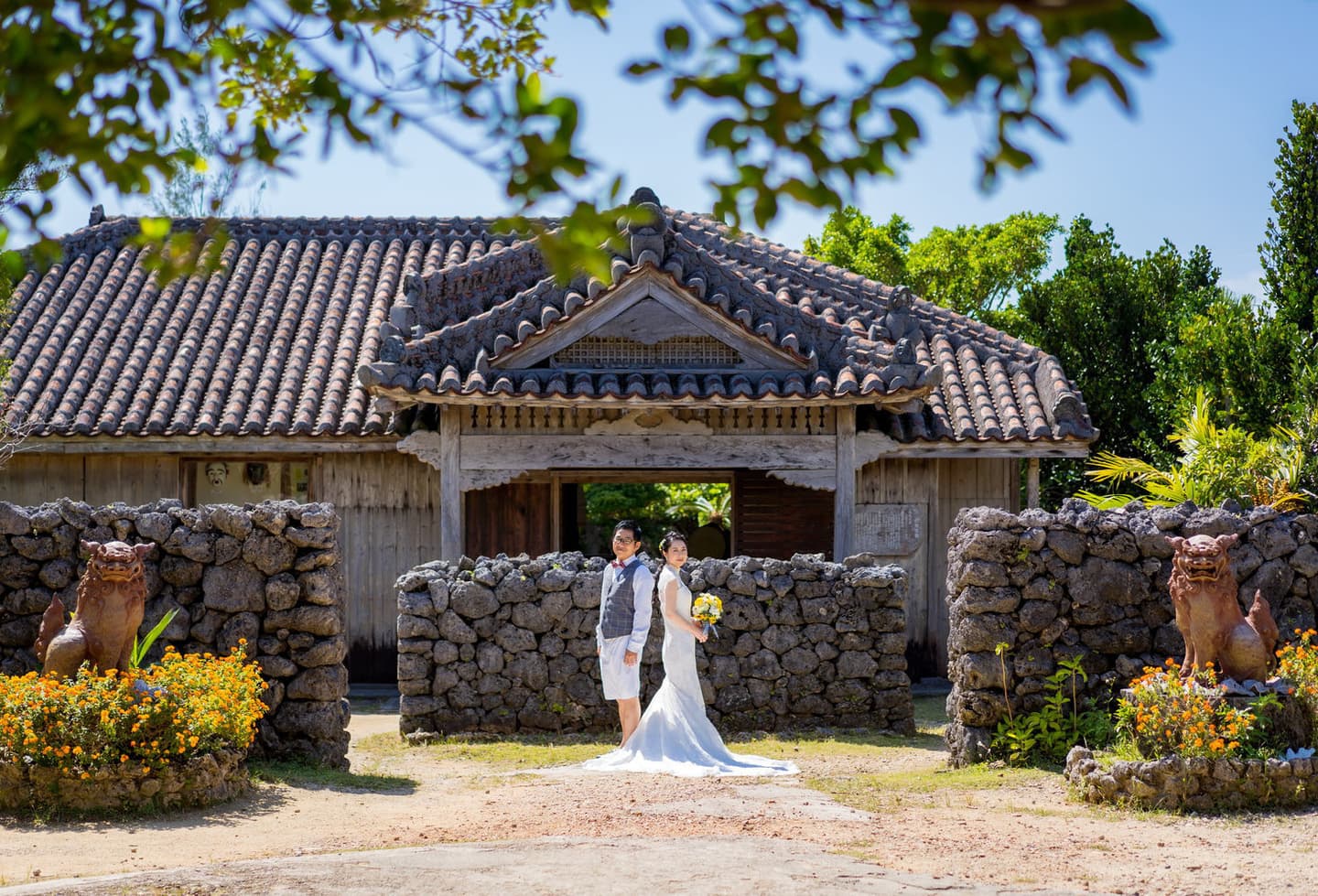 やいま村にある古民家の前に立つ新郎新婦