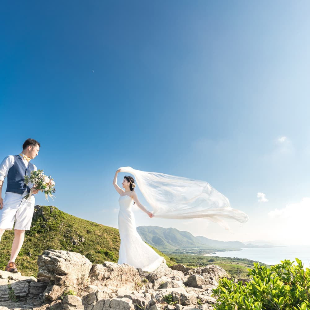 平久保崎灯台にある崖に立ってベールを靡かせる新婦と新郎