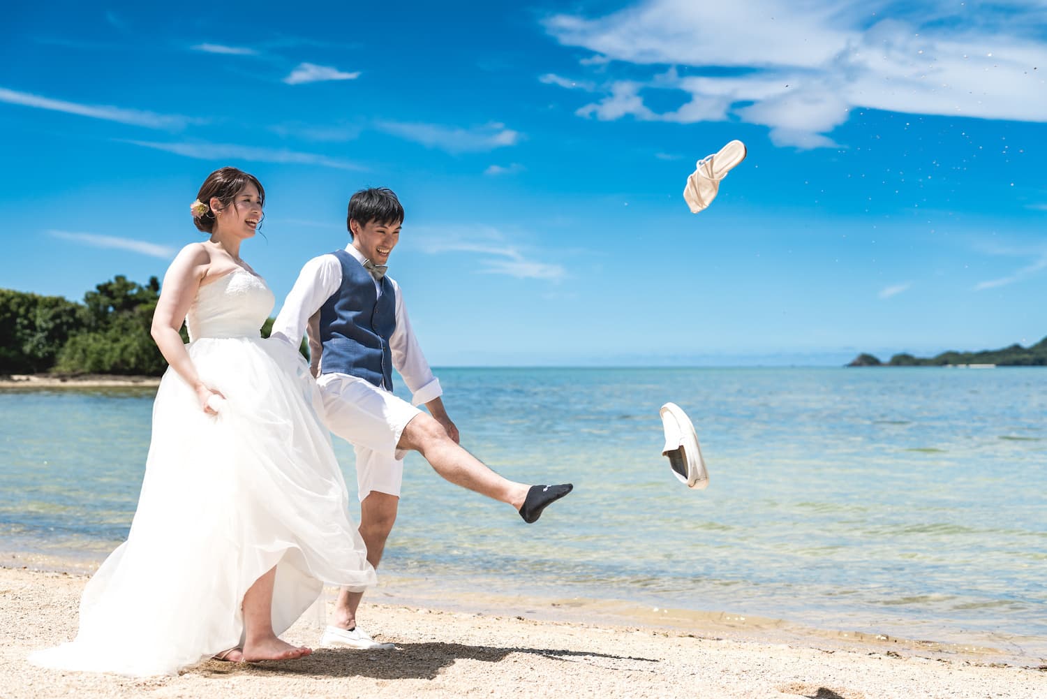 ビーチで靴を飛ばす新郎新婦