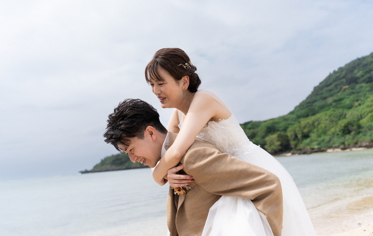 海の見える道で顔を寄せ合う新郎新婦