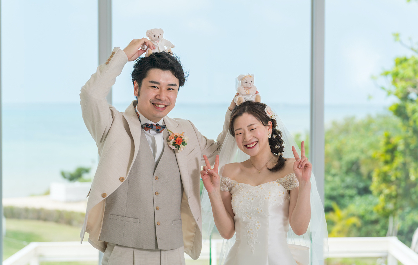 手で作ったハートの中で笑顔を見せる新郎新婦