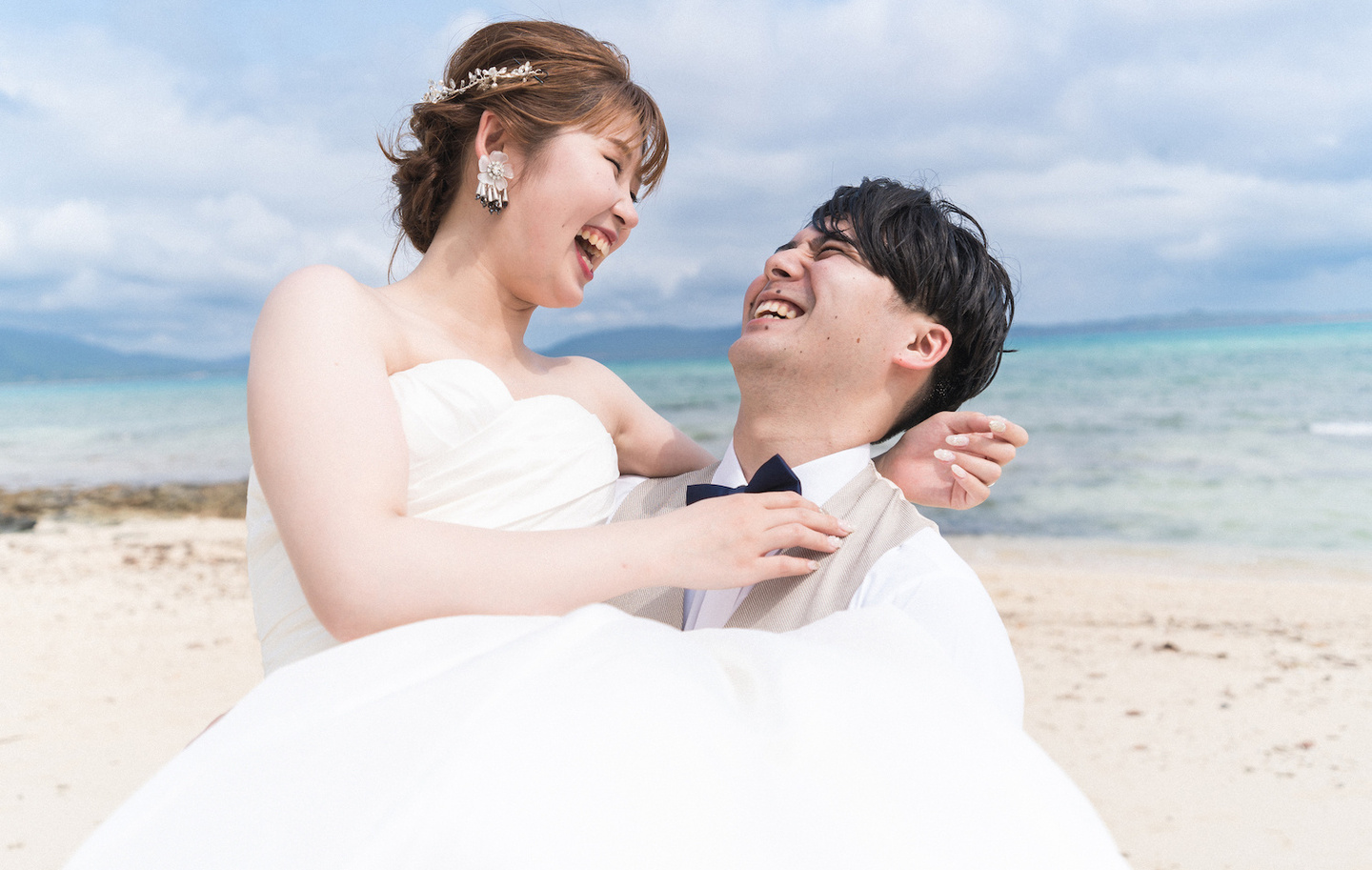 海の見える道で顔を寄せ合う新郎新婦