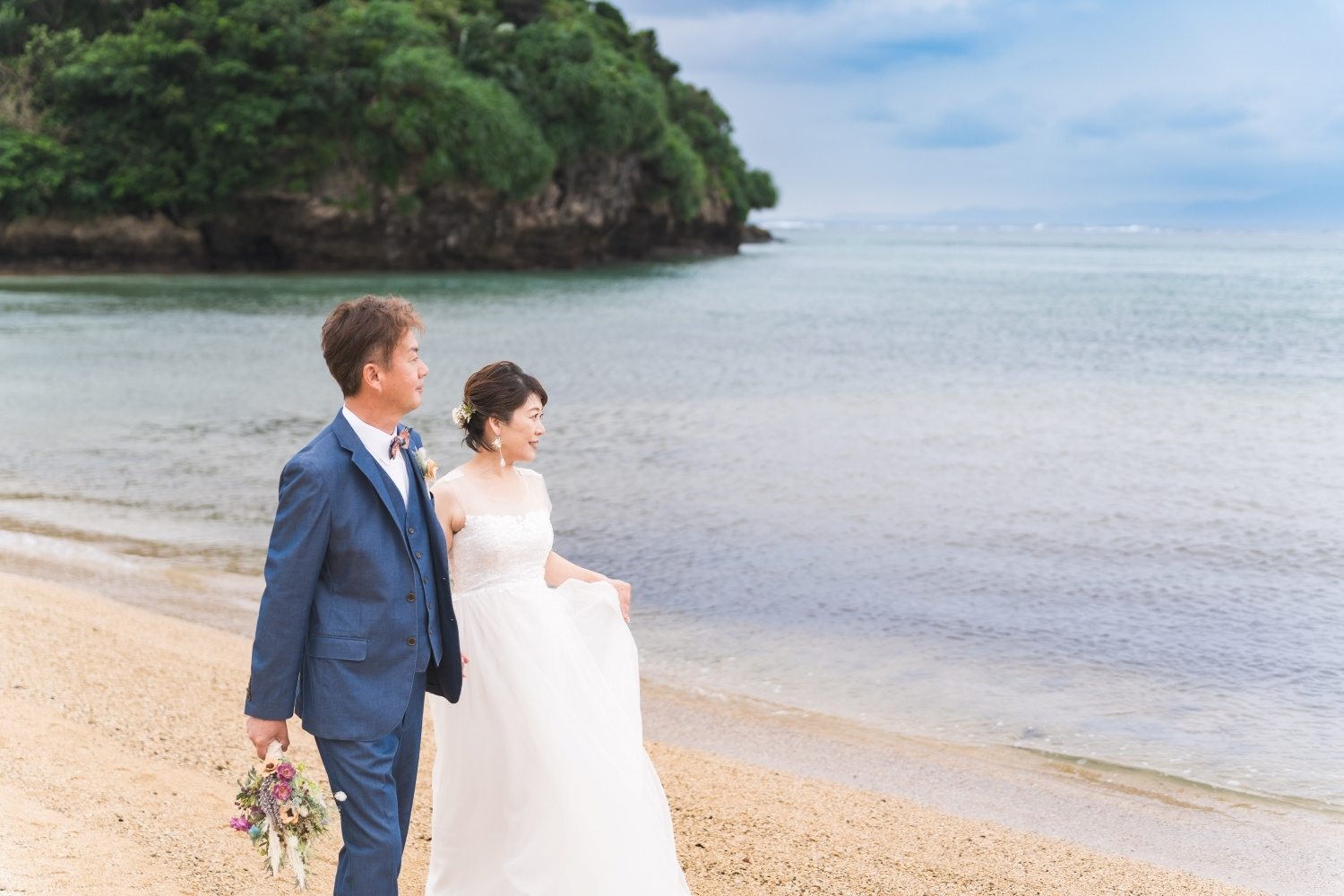 石垣島の海で浜辺を歩く新郎新婦