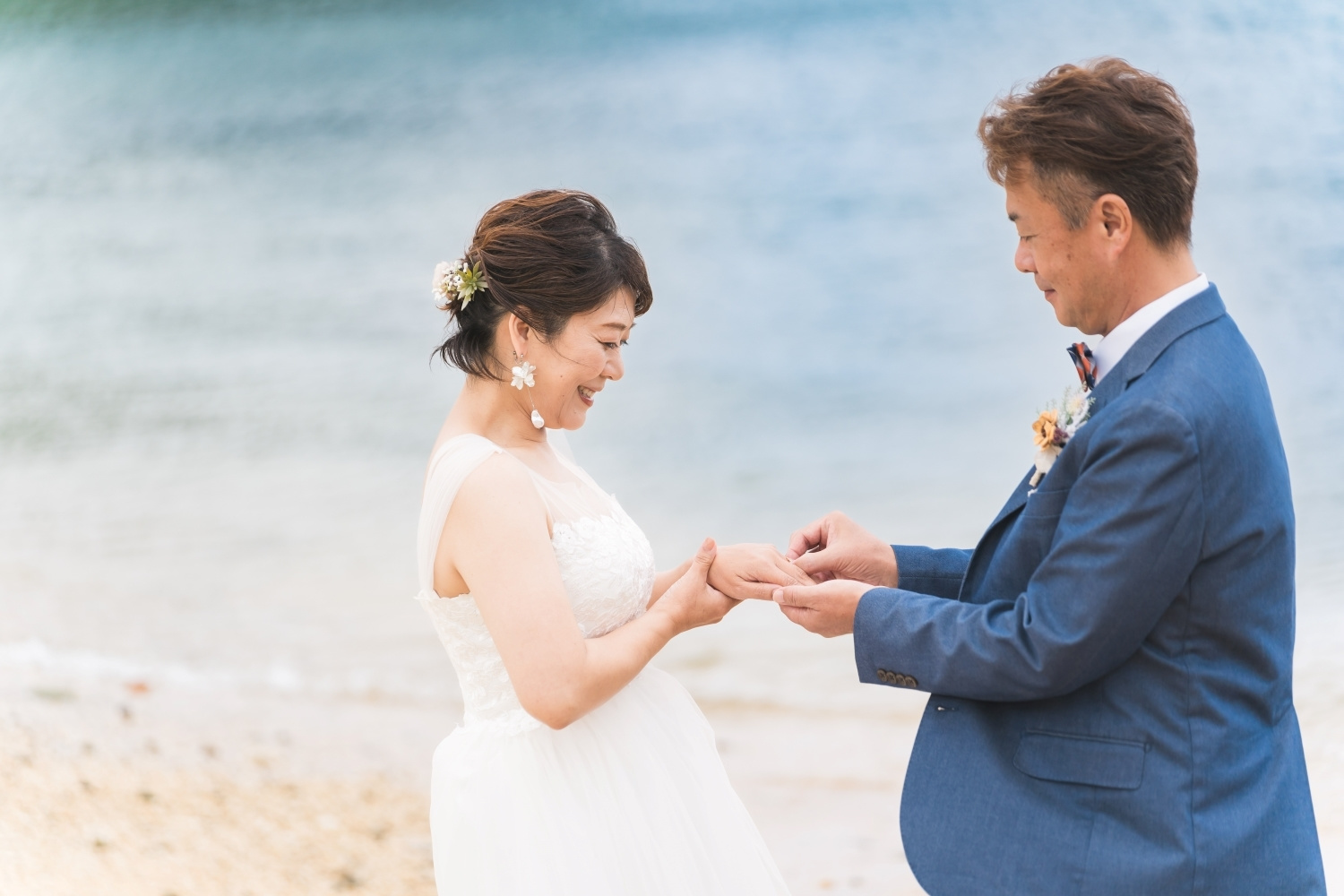 新婦の薬指に指輪をはめる新郎