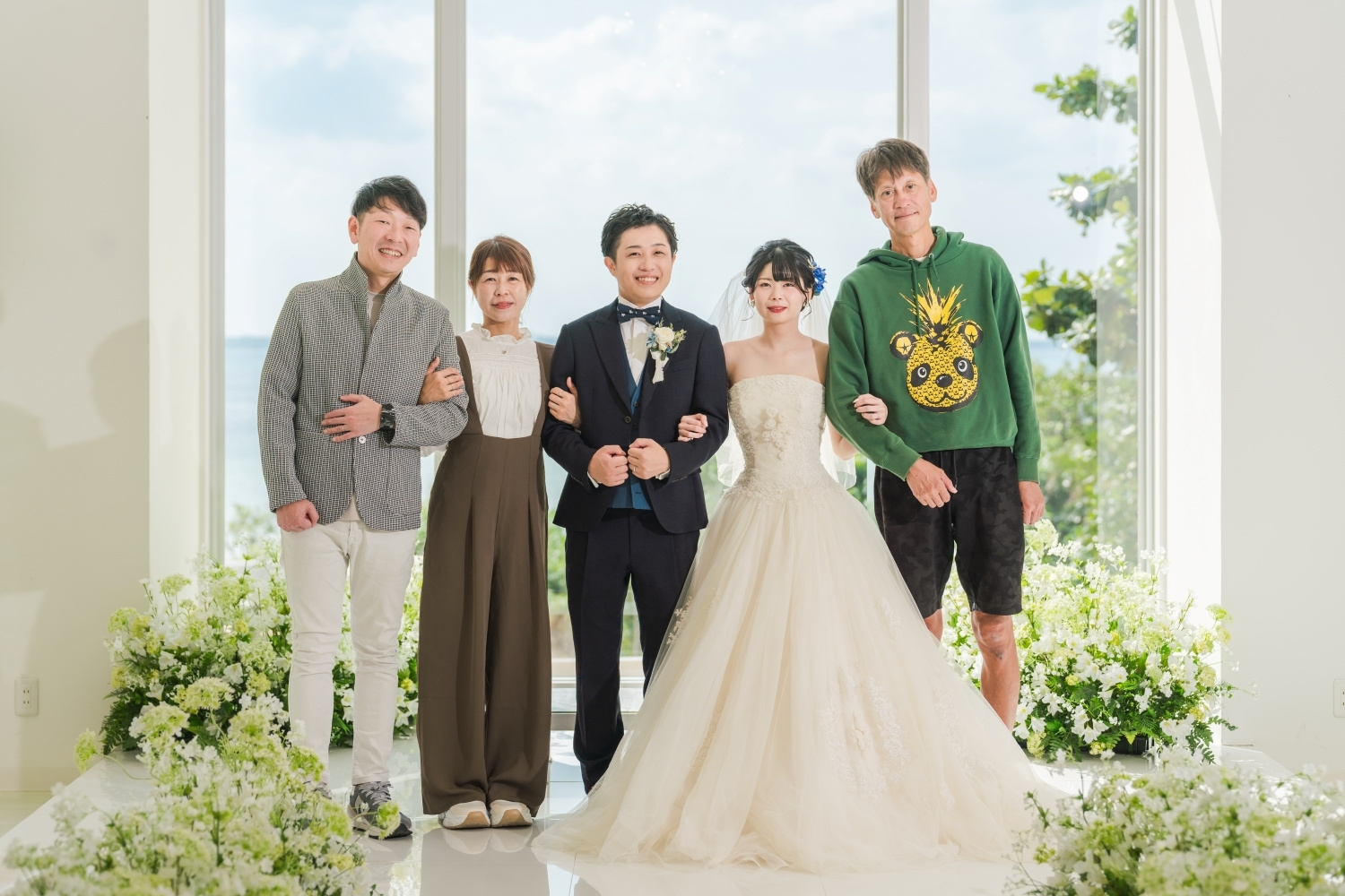 チャペルの祭壇で腕を組む新郎新婦と家族