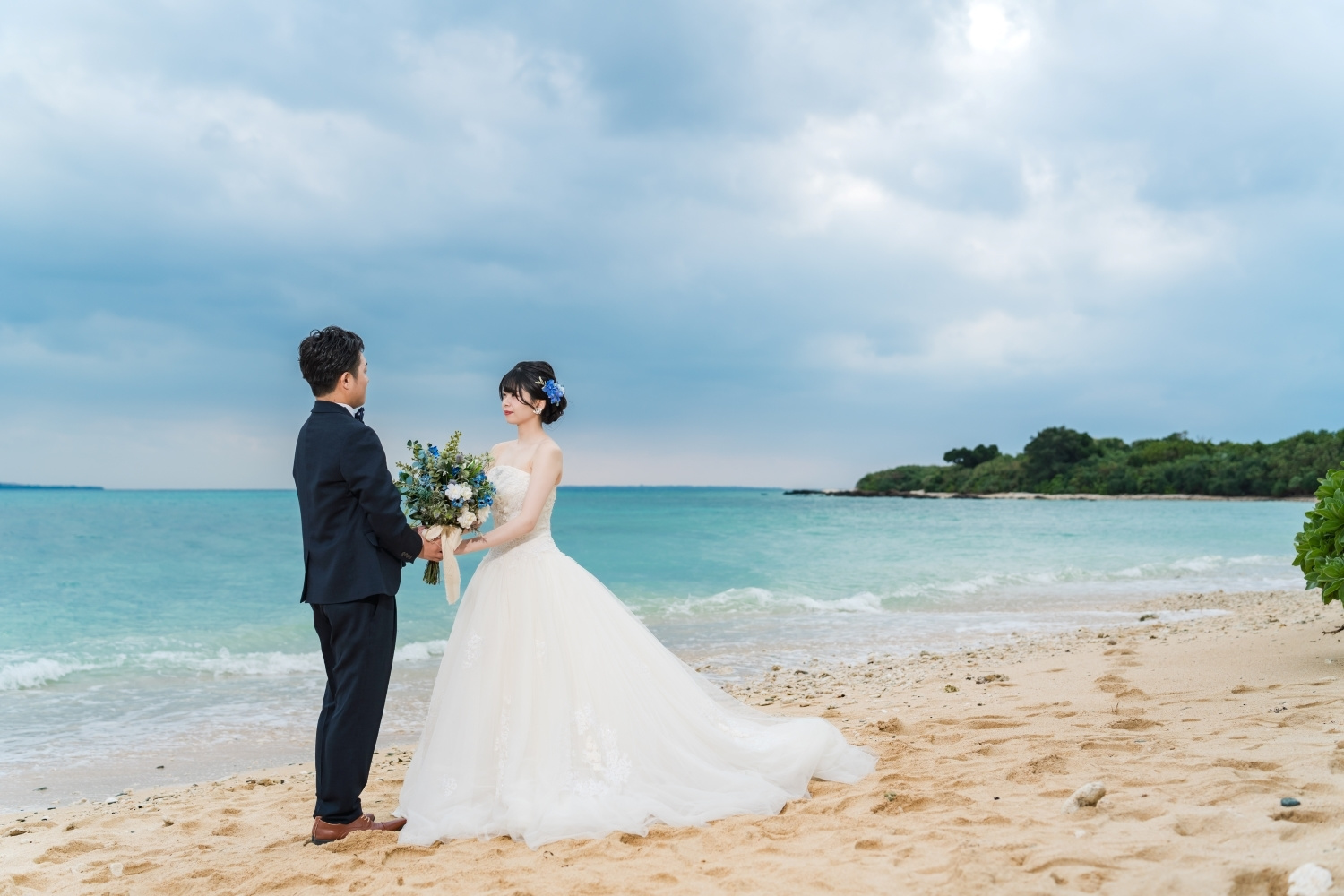 石垣島の海を背景にブーケを持つ新郎新婦
