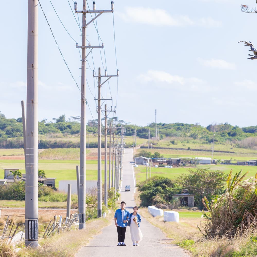 小浜島の一本道に立つ新郎新婦
