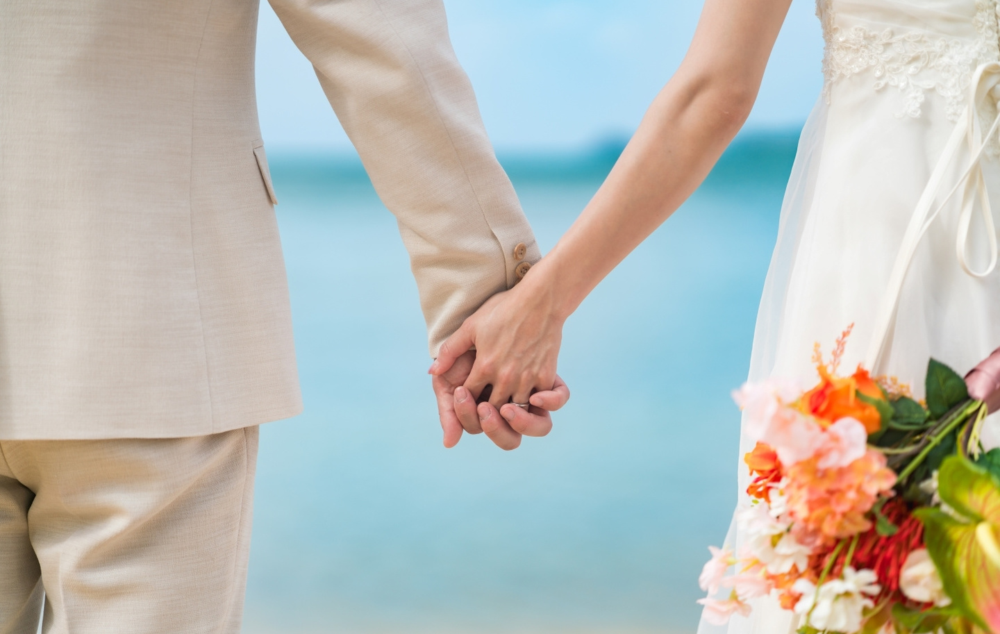 海の見える道で顔を寄せ合う新郎新婦