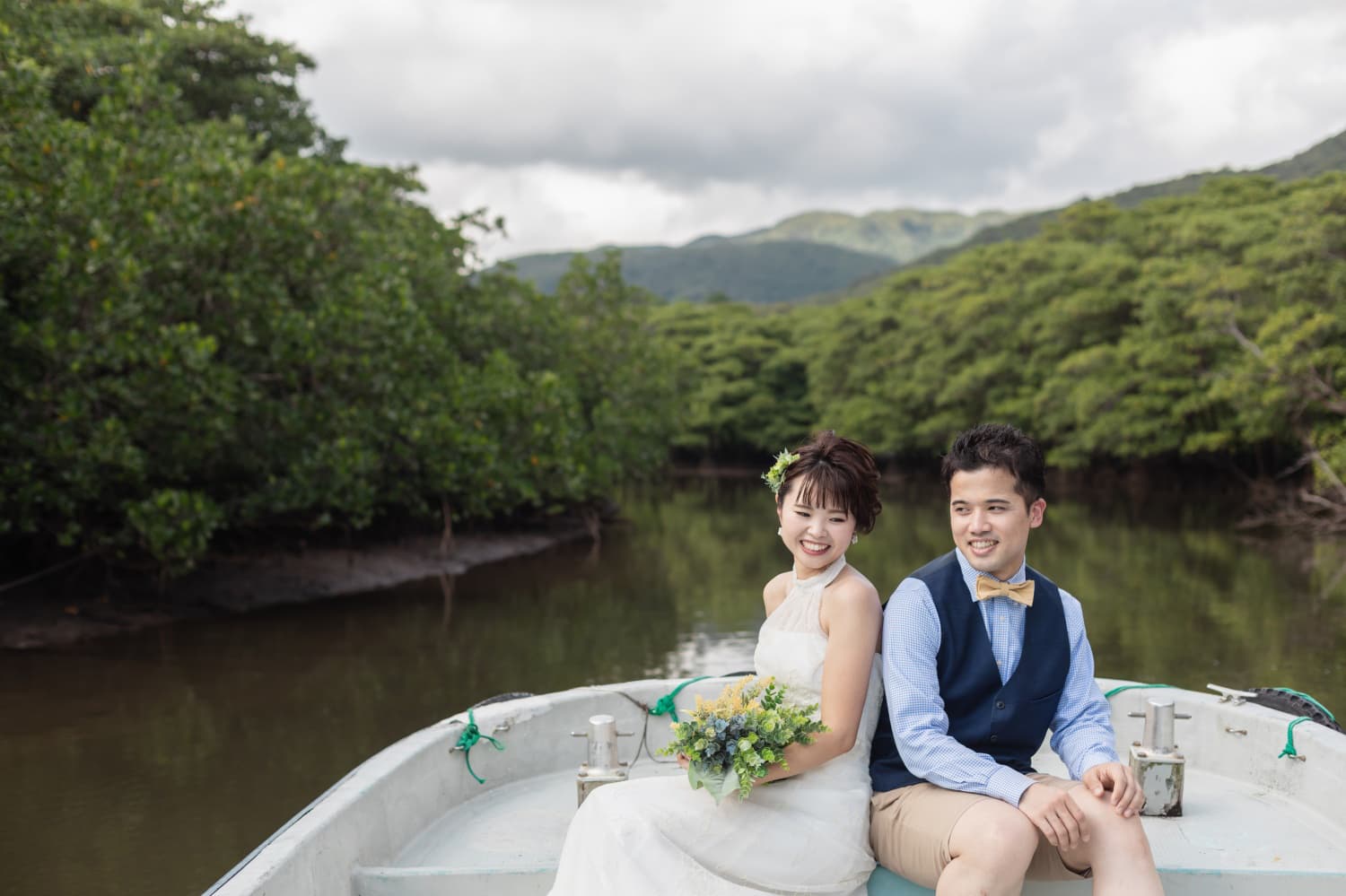 西表島でボートに座る新郎新婦