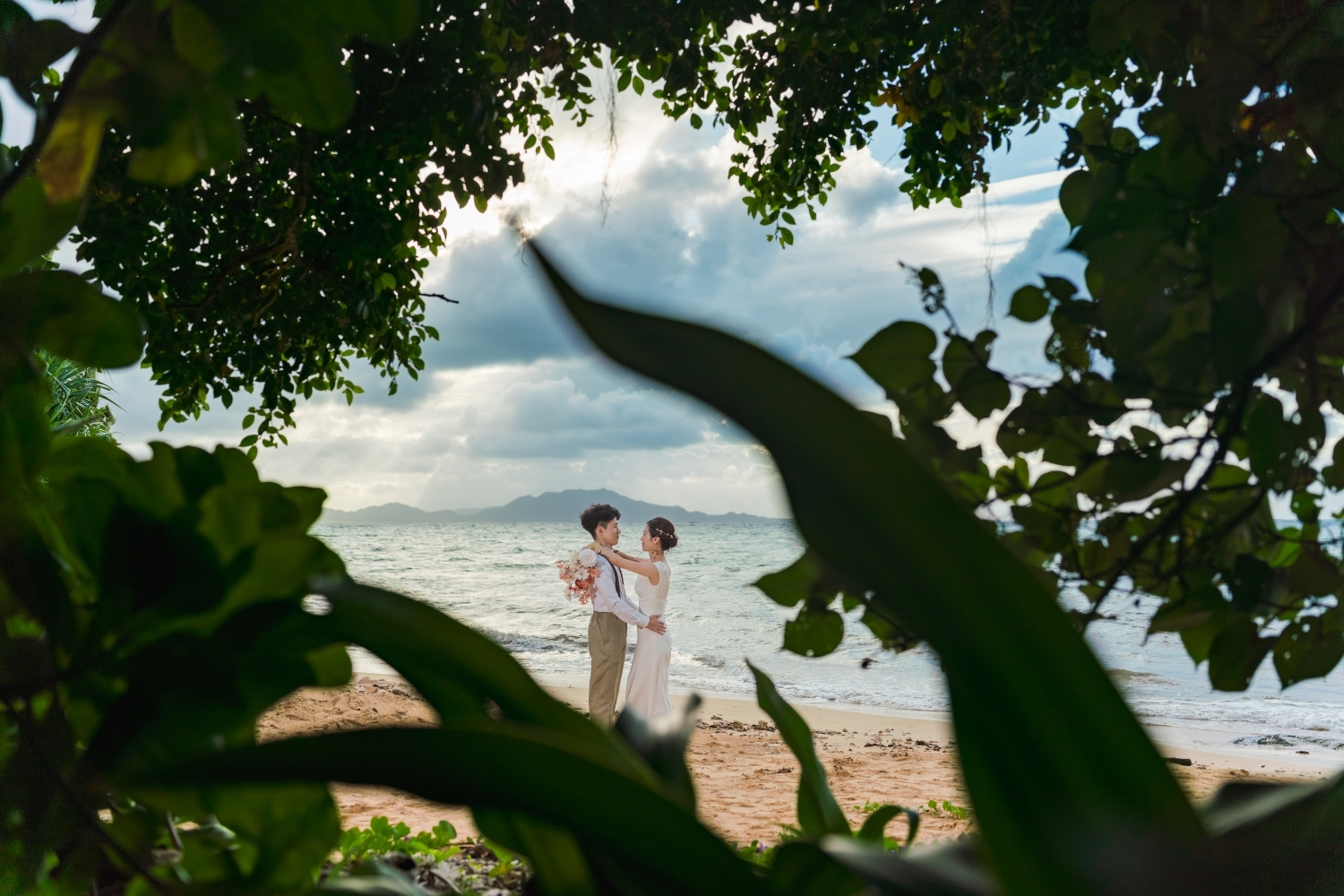 石垣島の海を背景に抱き合う新郎新婦
