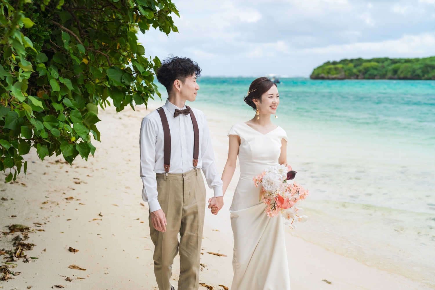 川平湾の砂浜を歩く新郎新婦