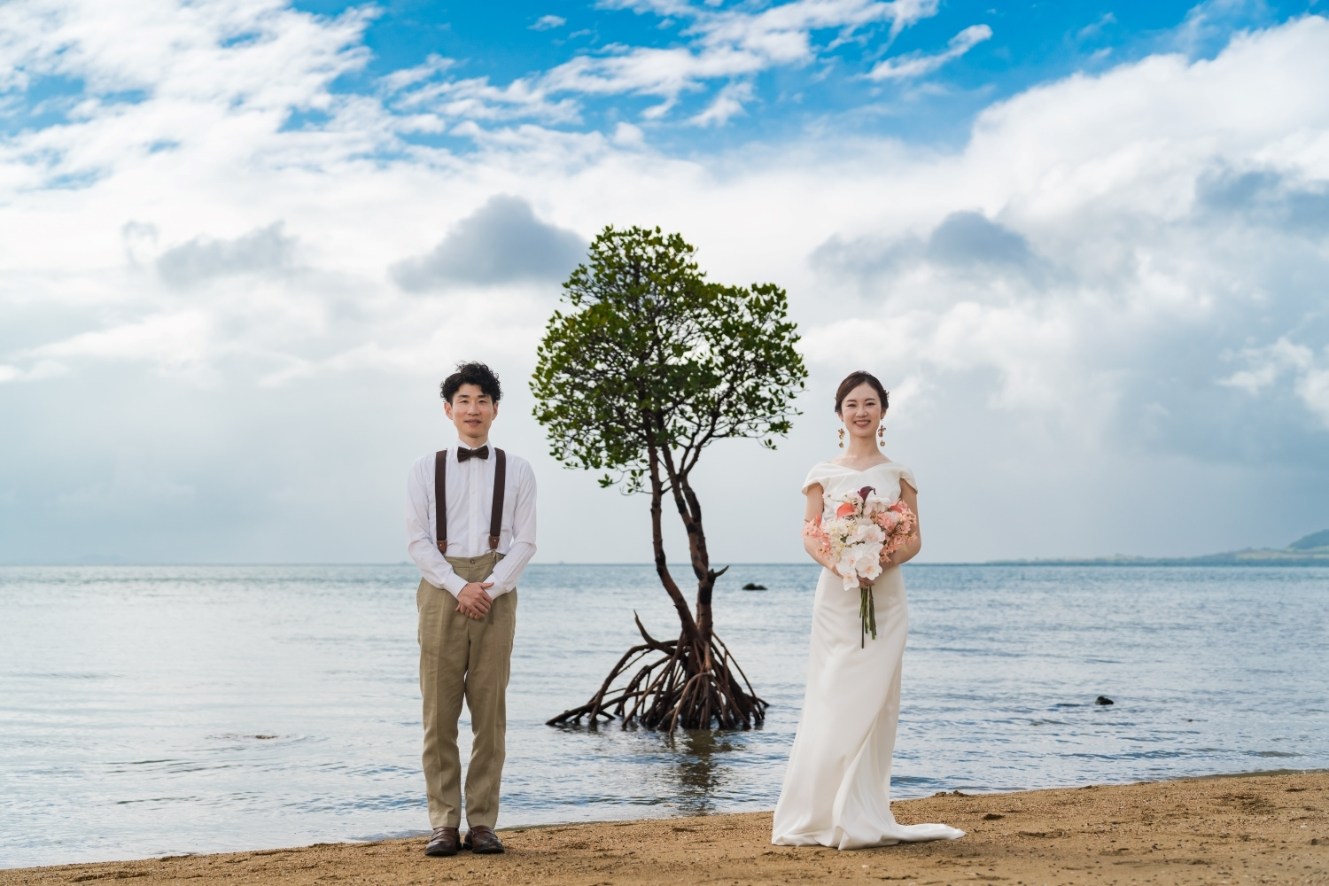 名蔵湾のマングローブの前に立つ新郎新婦