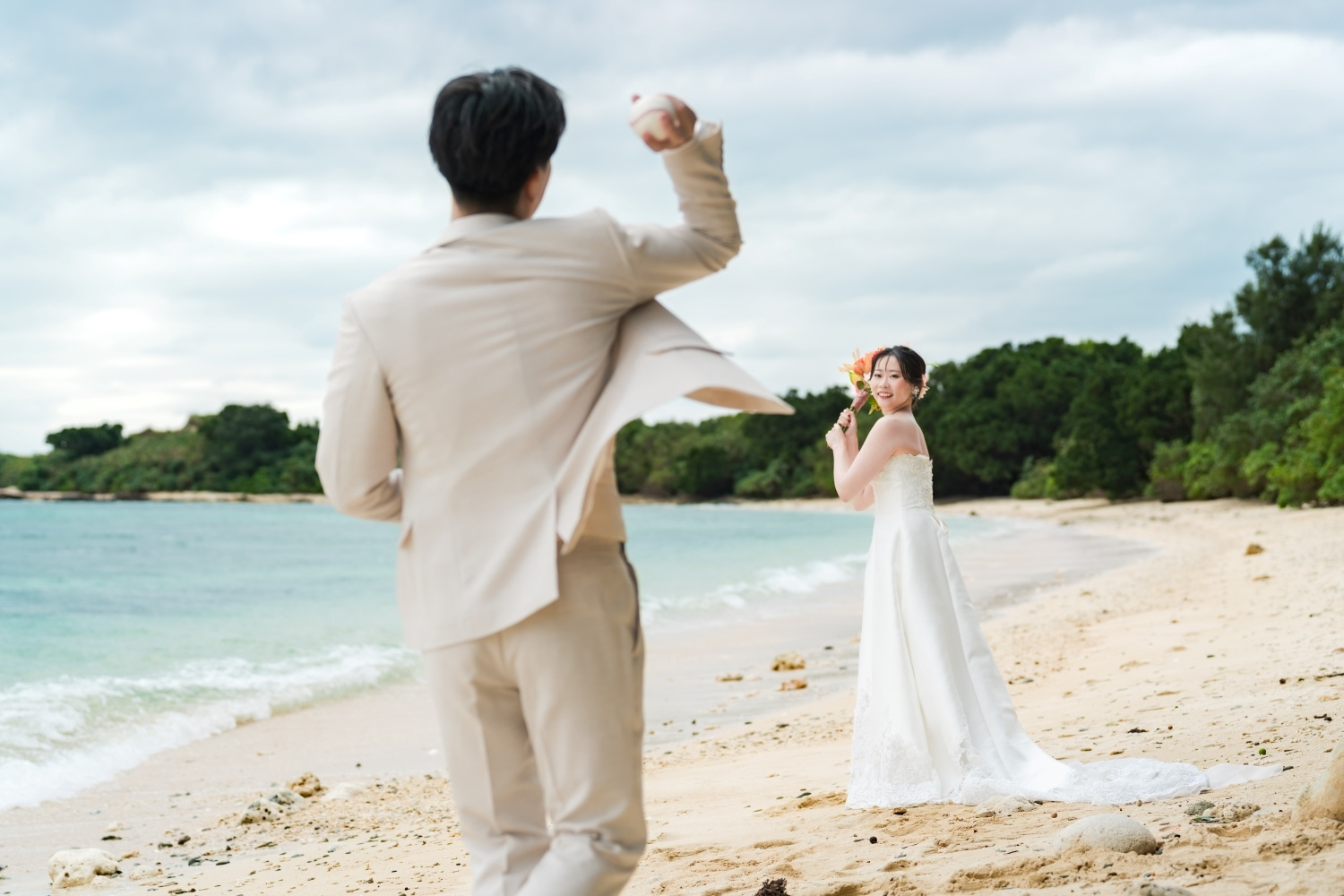 石垣島の浜辺でキャッチボールをする新郎新婦