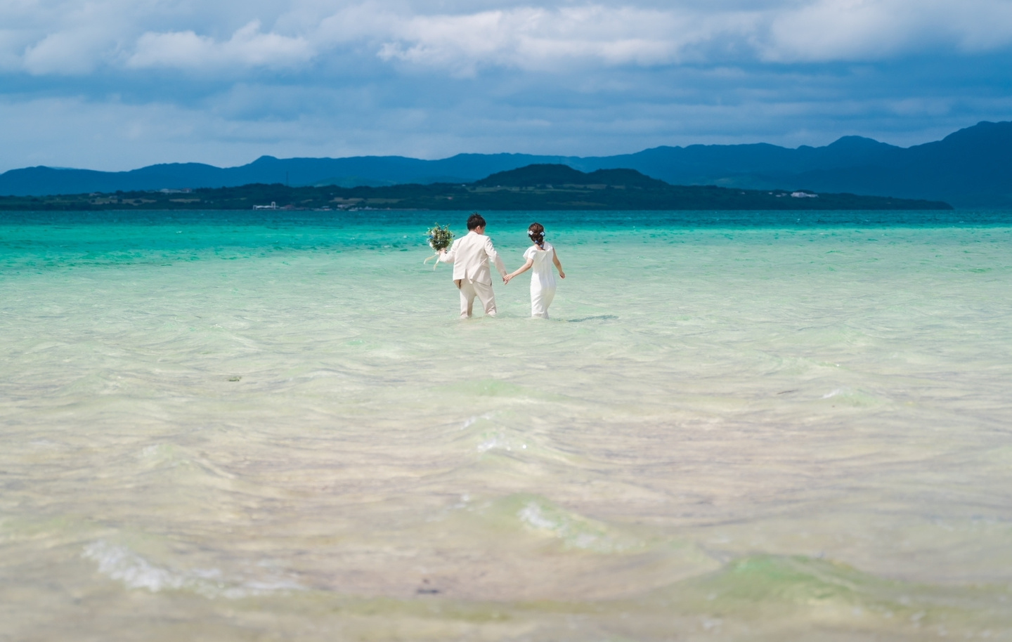 川平湾を背景に見つめ合う新郎新婦