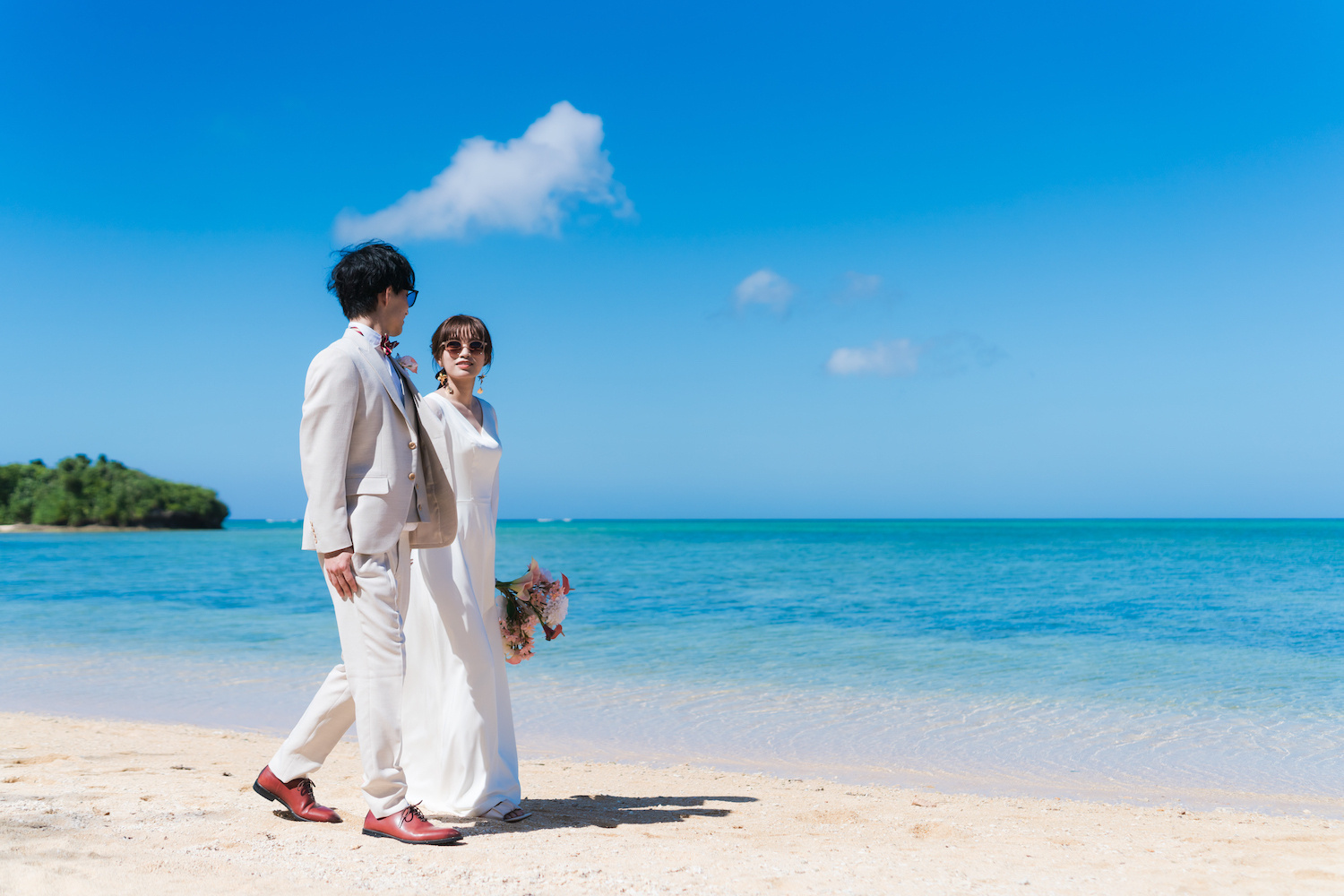 浜辺を歩く新郎新婦