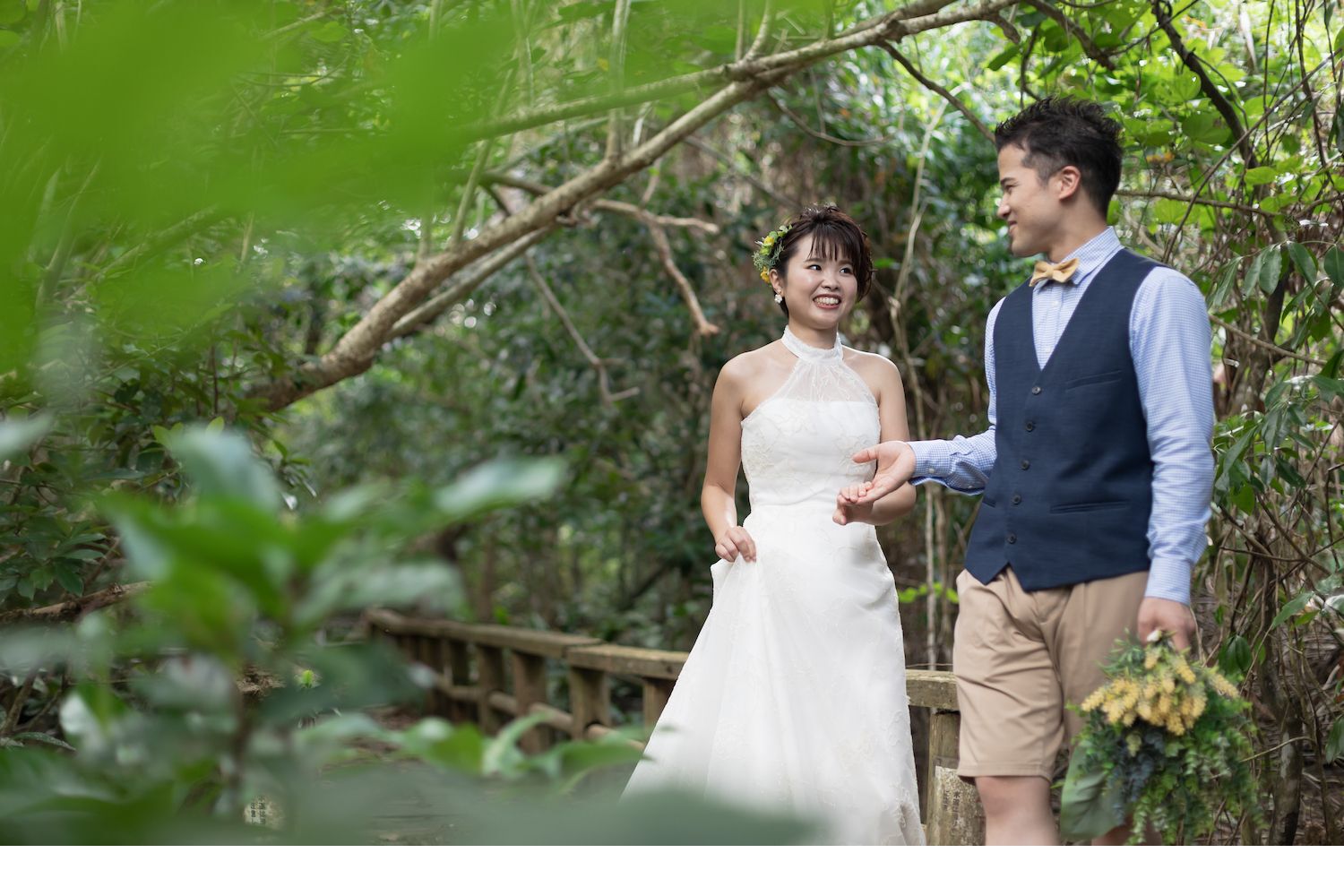 西表島の緑に囲まれて新婦の手を引く新郎